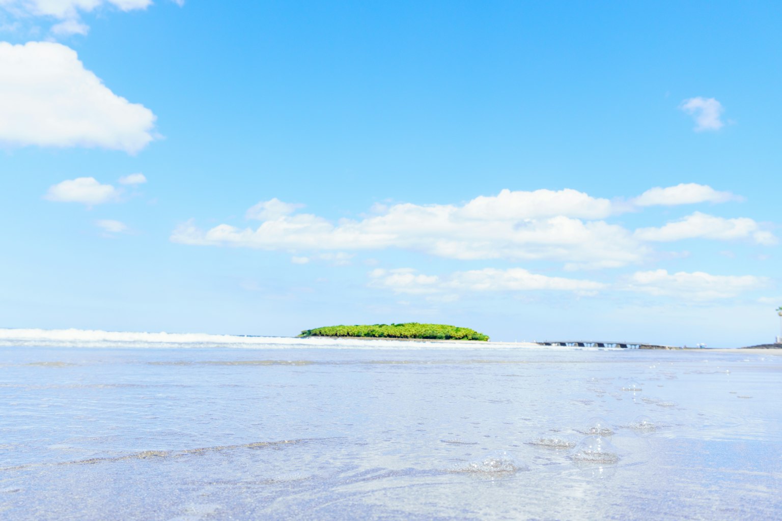 Piccola isola circondata da un mare calmo e cielo azzurro