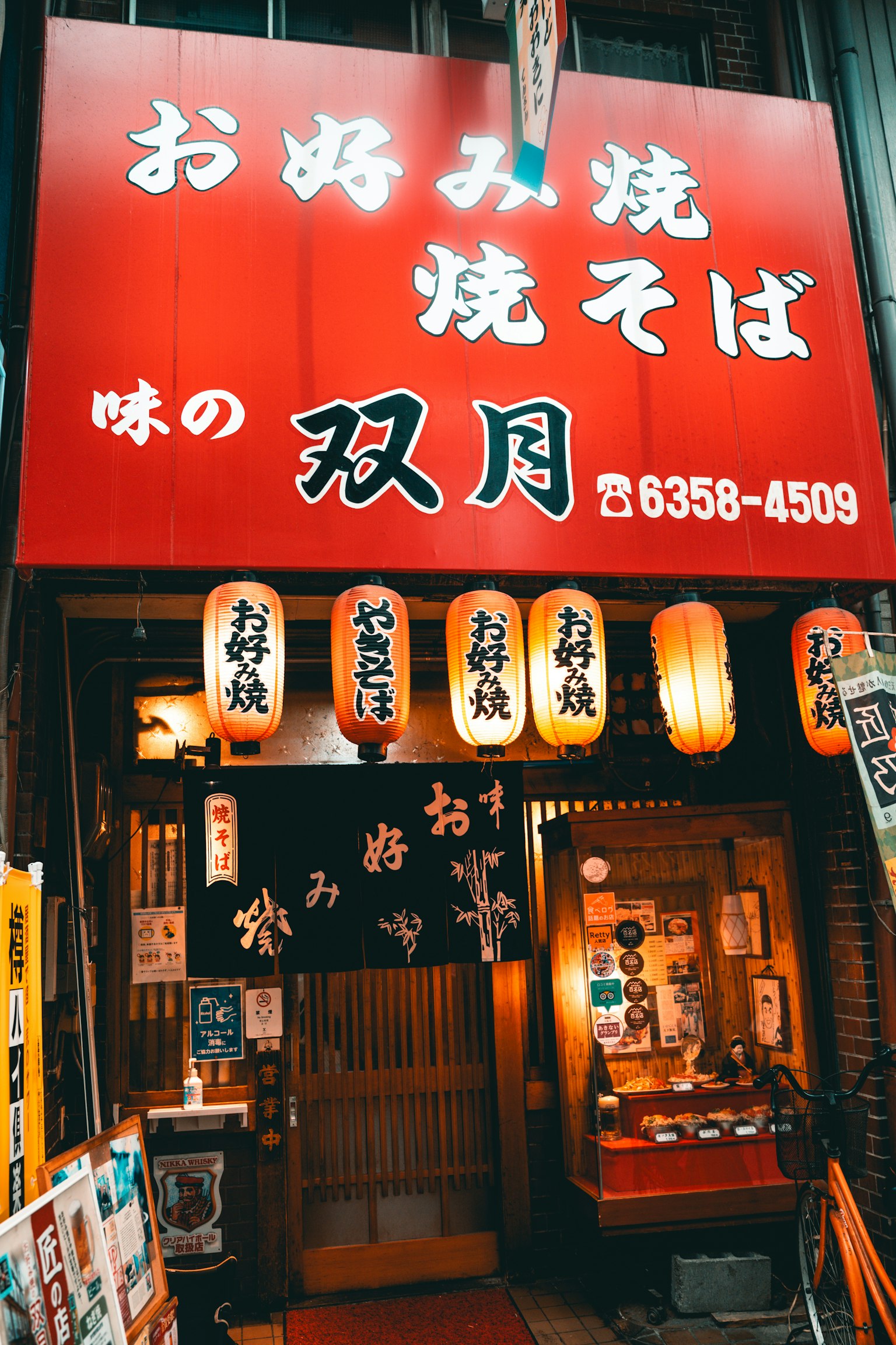 红色招牌的铁板烧餐厅外观 照明的灯笼展示