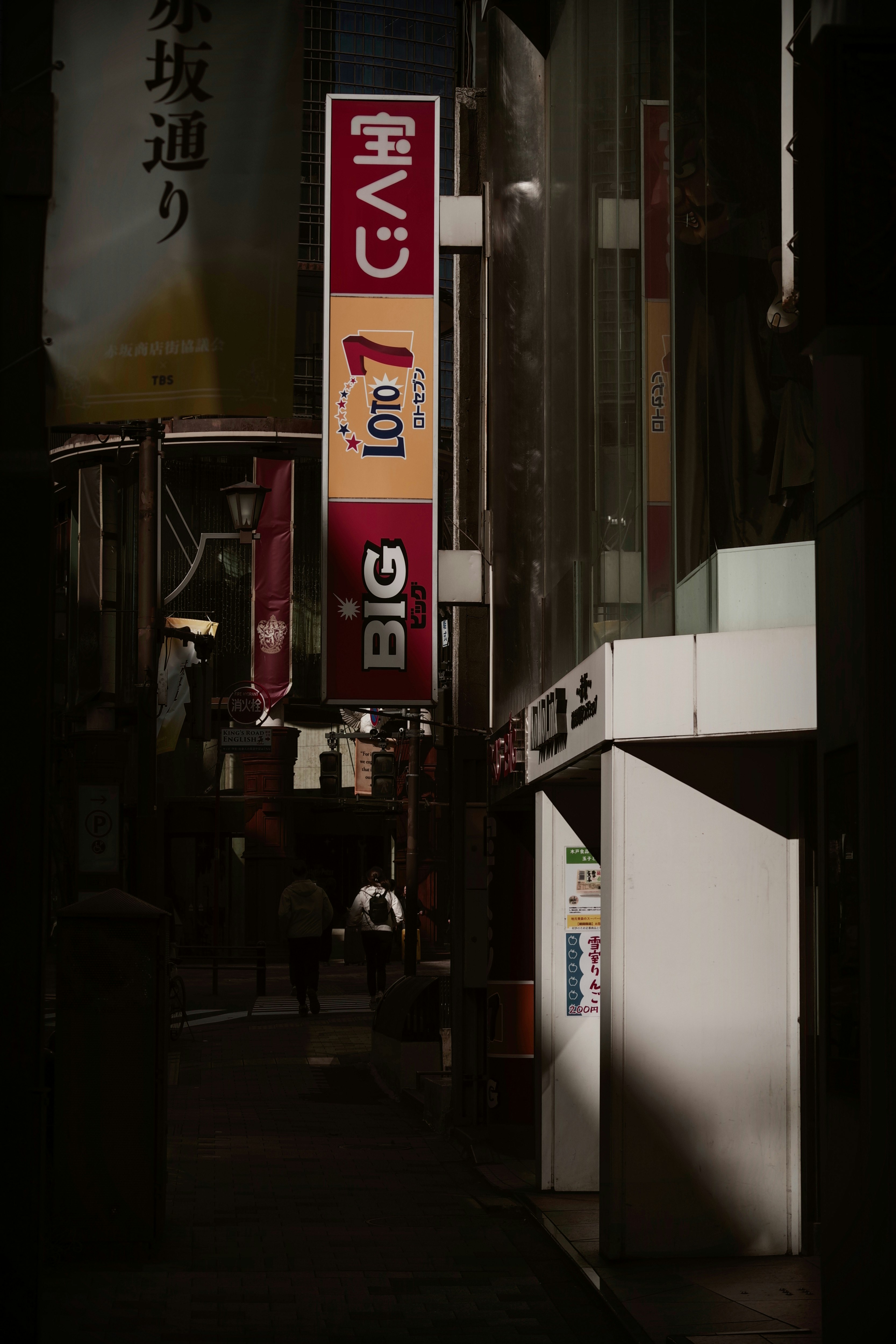 路地に並ぶ宝くじの看板と広告のある商店街の夜景