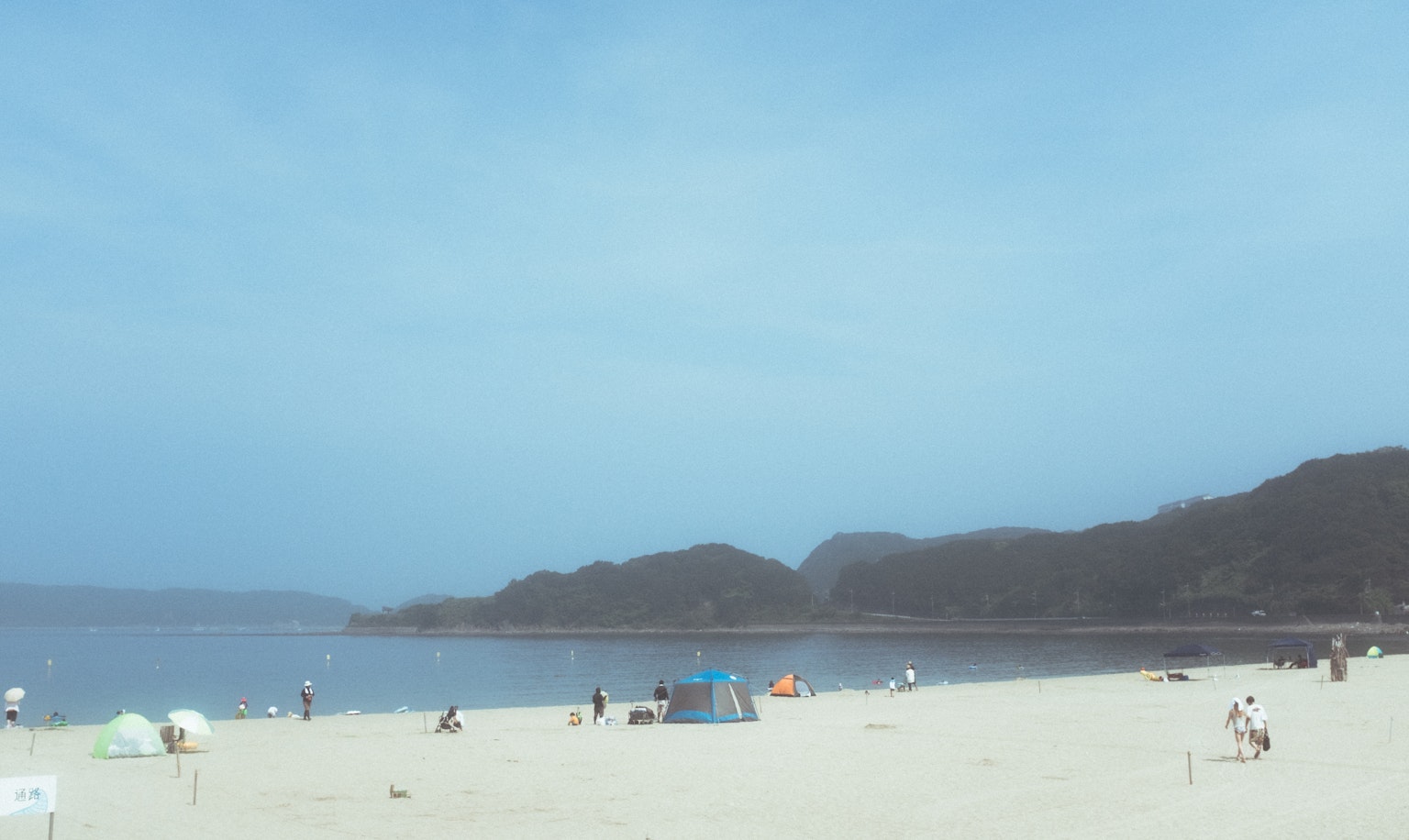 해변 풍경, 사람들과 푸른 하늘 그리고 배경의 산들