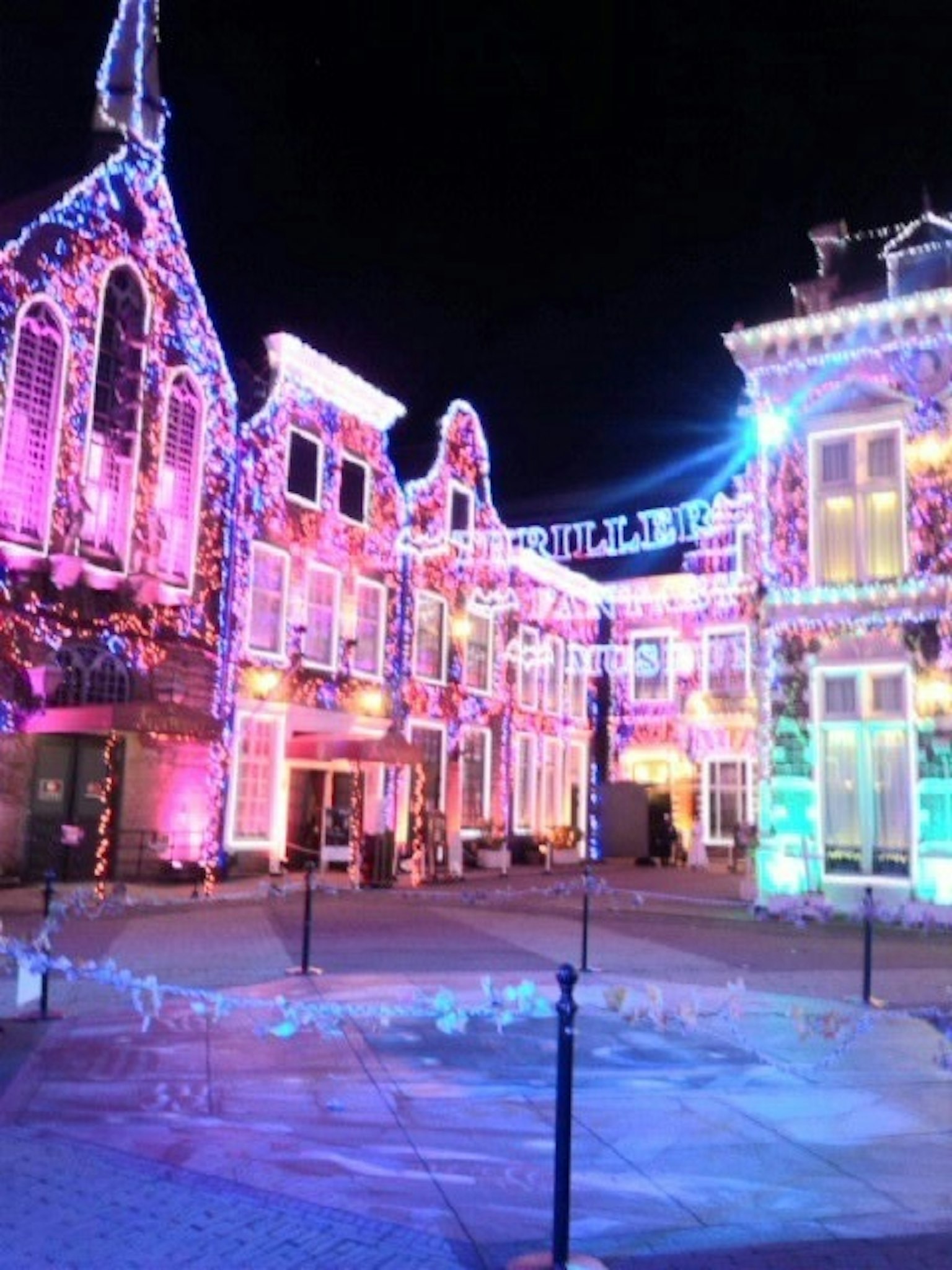 Vista notturna di edifici storici illuminati da luci colorate