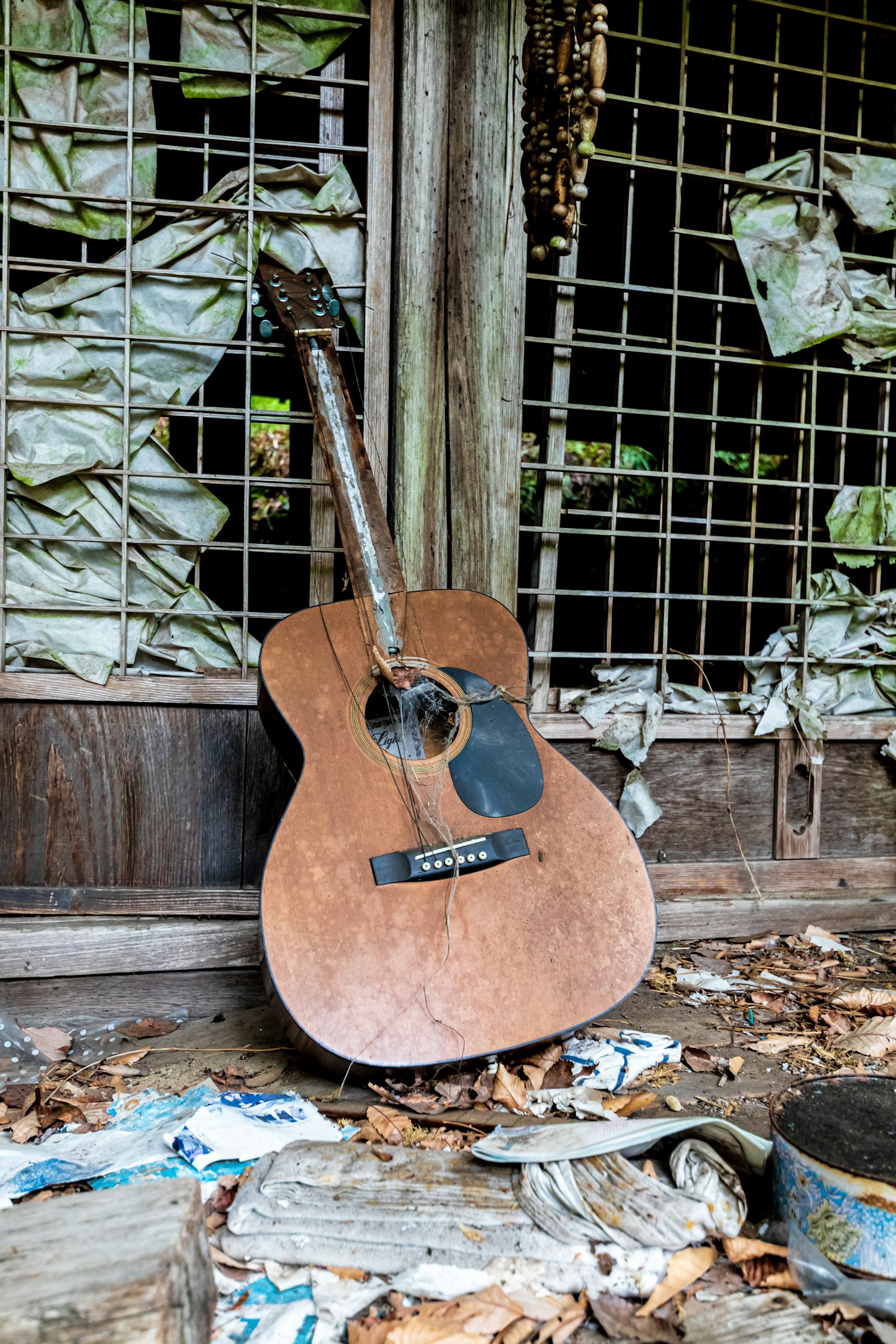 Eine abgenutzte Akustikgitarre in einem verlassenen Raum