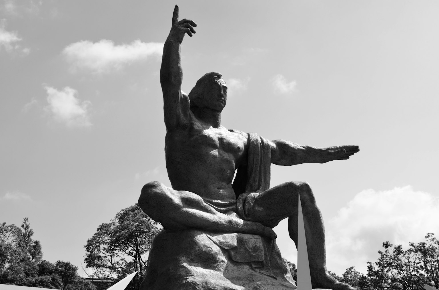 Statua in bianco e nero seduta con un braccio alzato