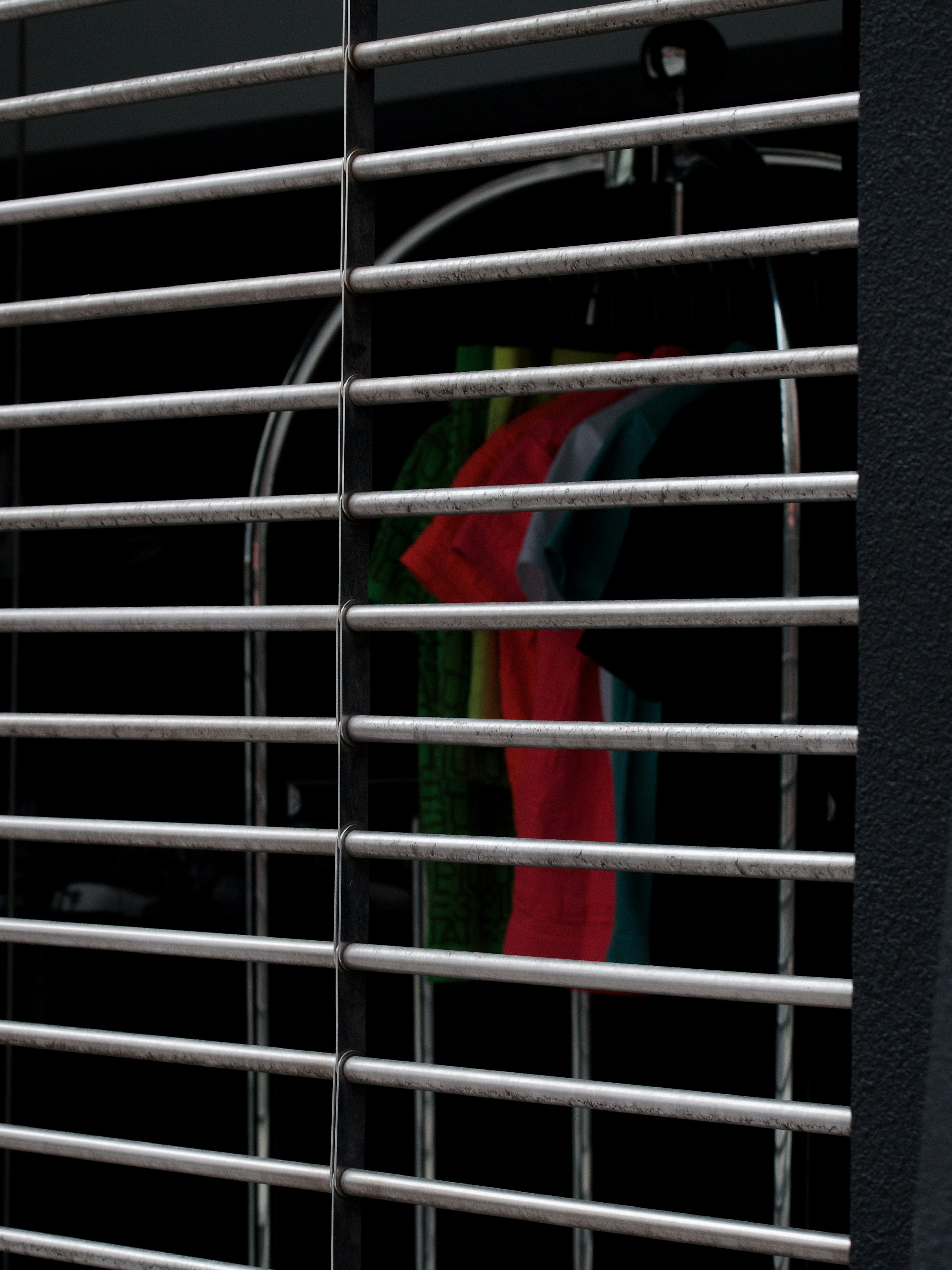 Colorful clothing partially visible behind metal bars