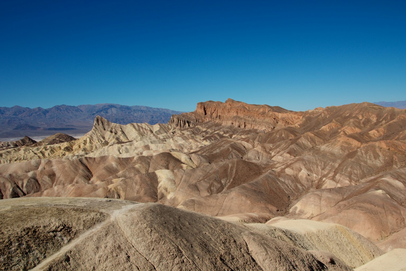Vista panoramica di montagne a strati colorati sotto un cielo azzurro