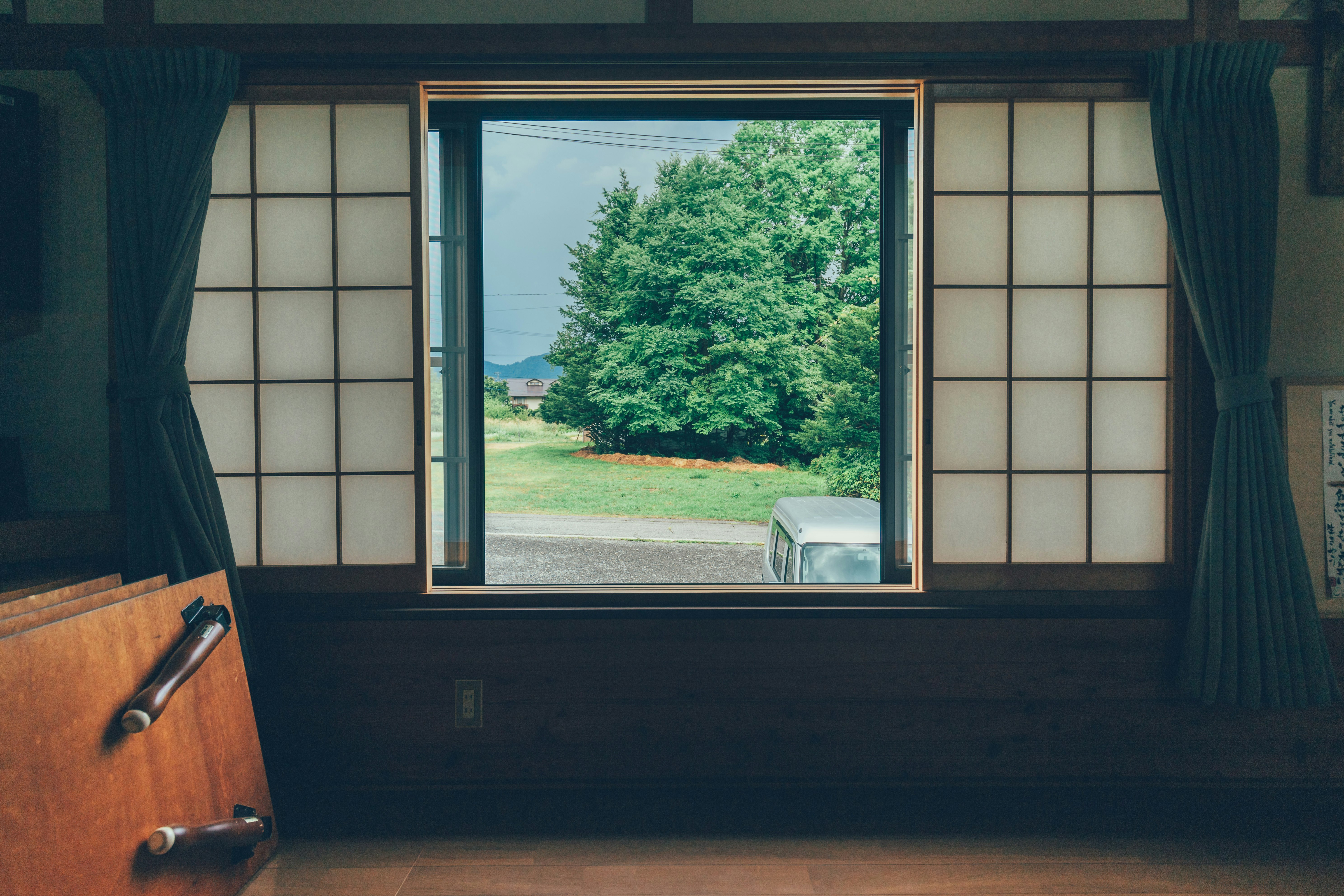 Vue intérieure avec une fenêtre donnant sur un jardin vert et la campagne