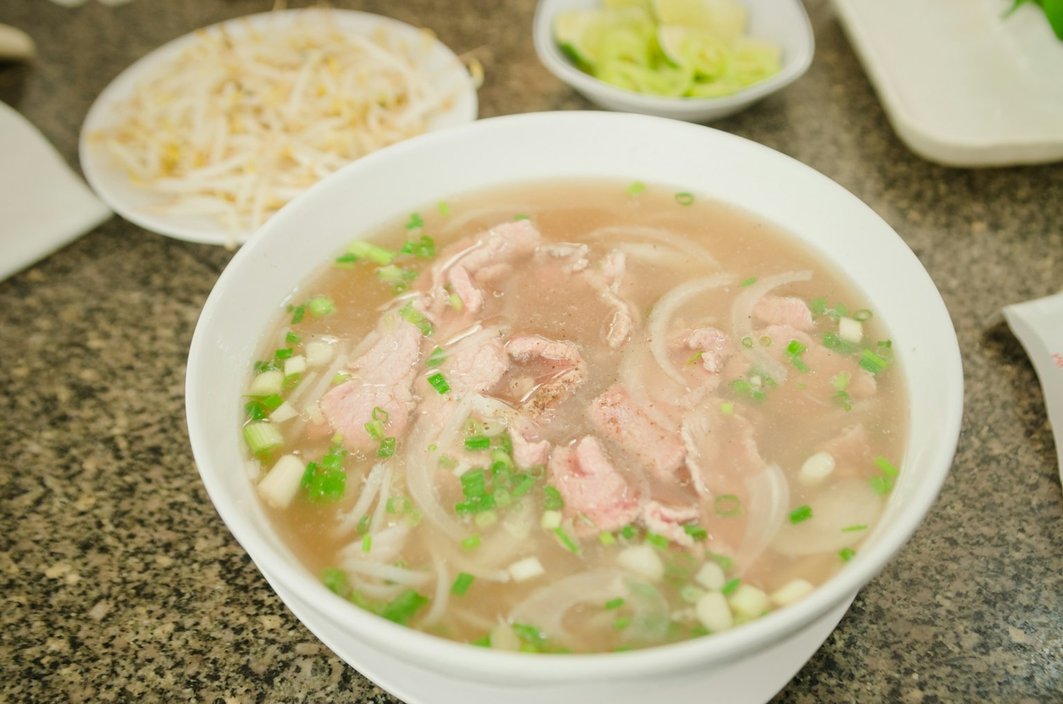 Ciotola di zuppa pho con carne affettata e cipolle verdi sopra