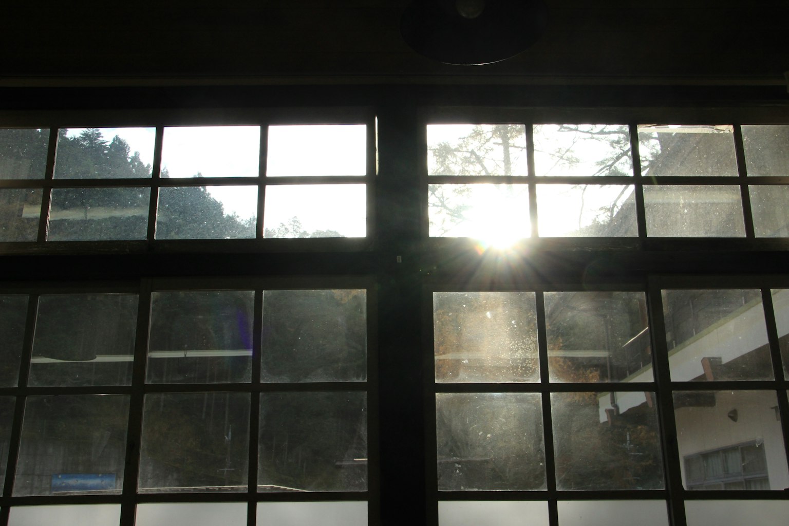 Vista a través de ventanas con luz solar y silueta de montaña