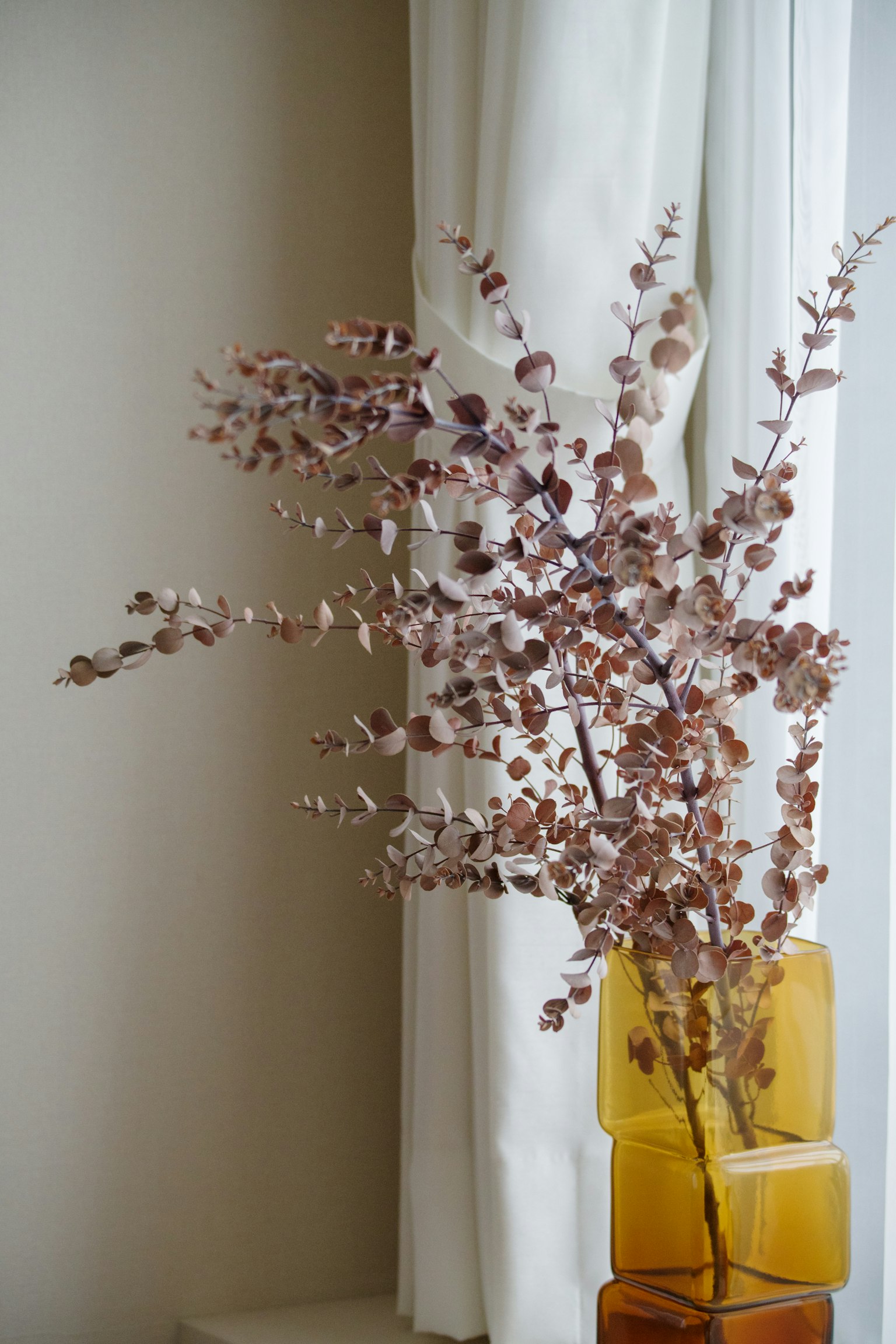A beautiful arrangement of dried flowers in a yellow vase