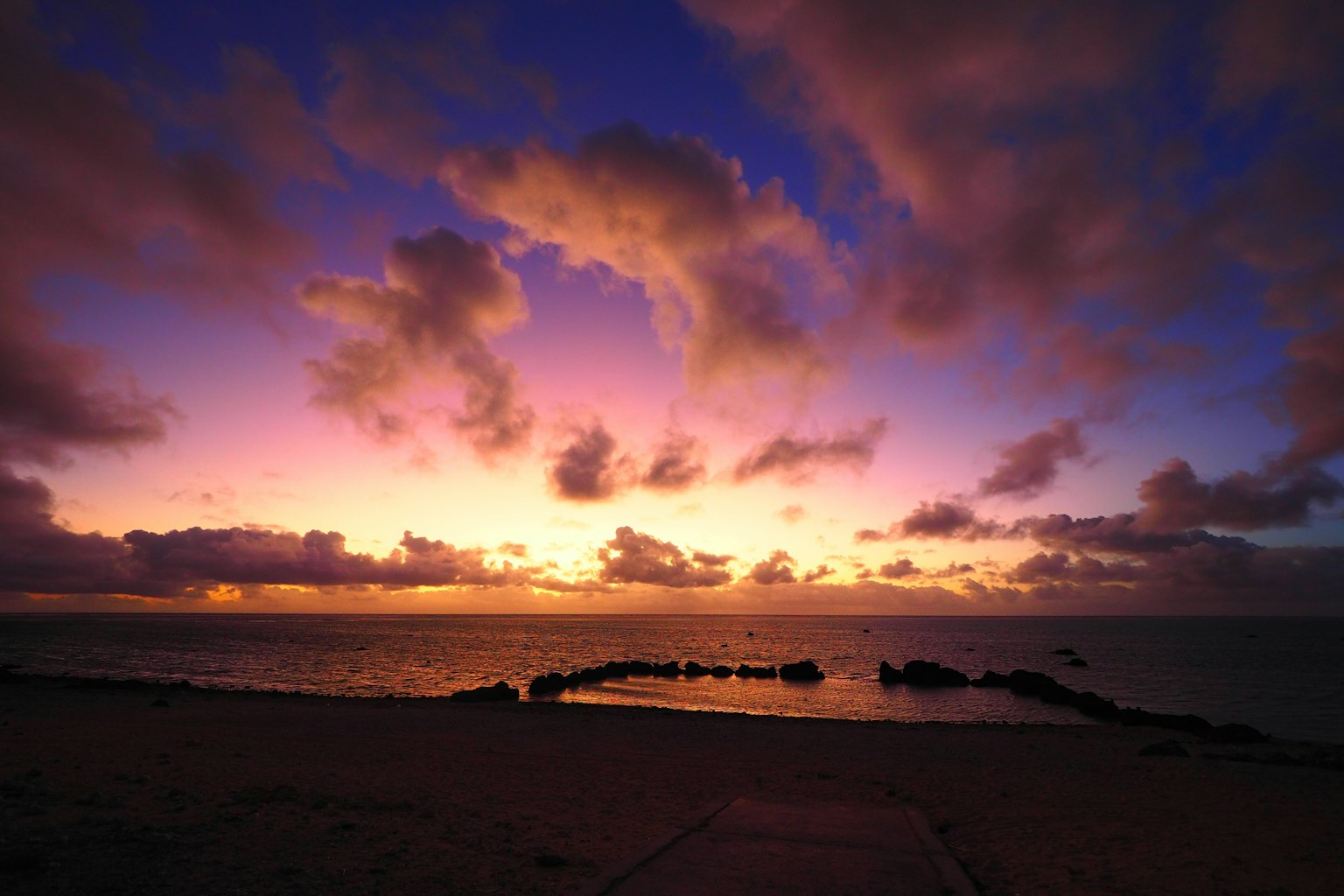 Vibrant purple and orange sky over a coastal sunset