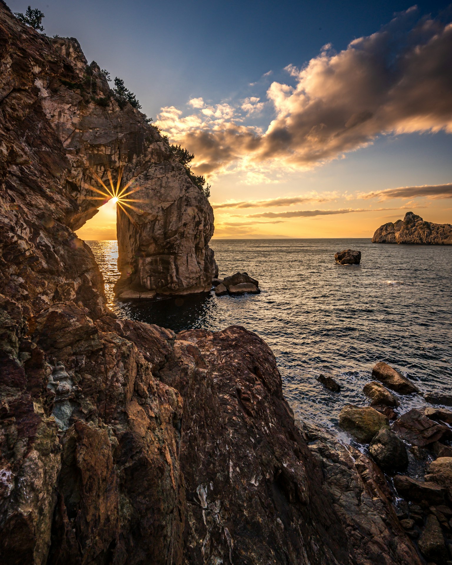 Splendido paesaggio marino con un arco roccioso e un tramonto splendente