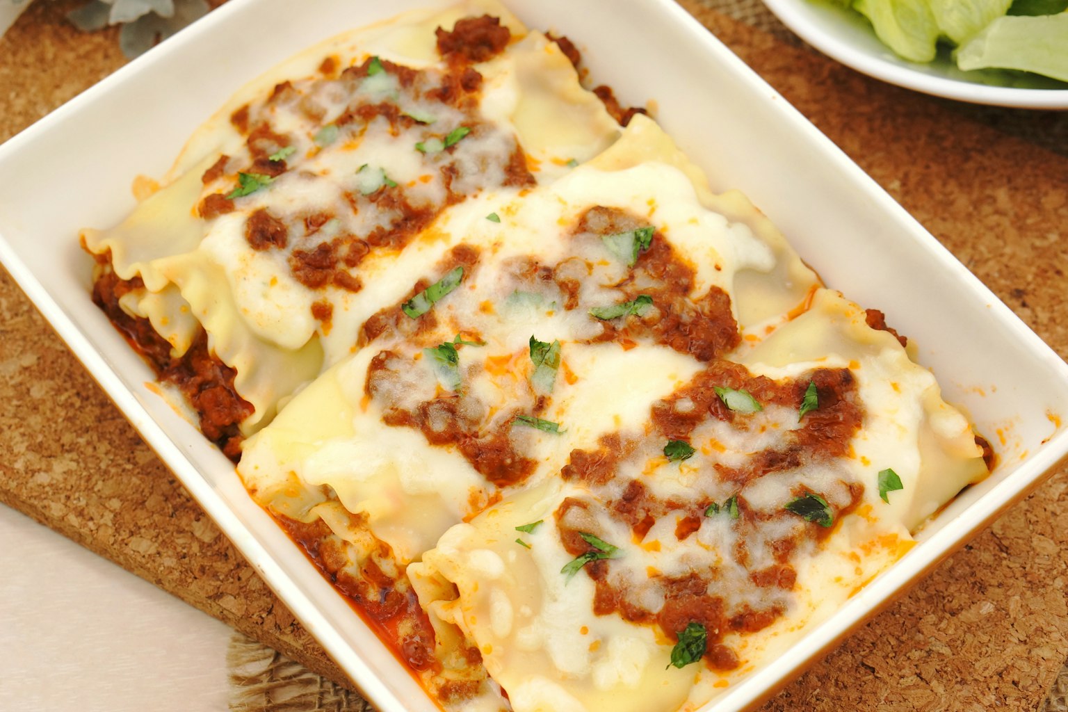 A dish of lasagna topped with cheese and meat sauce