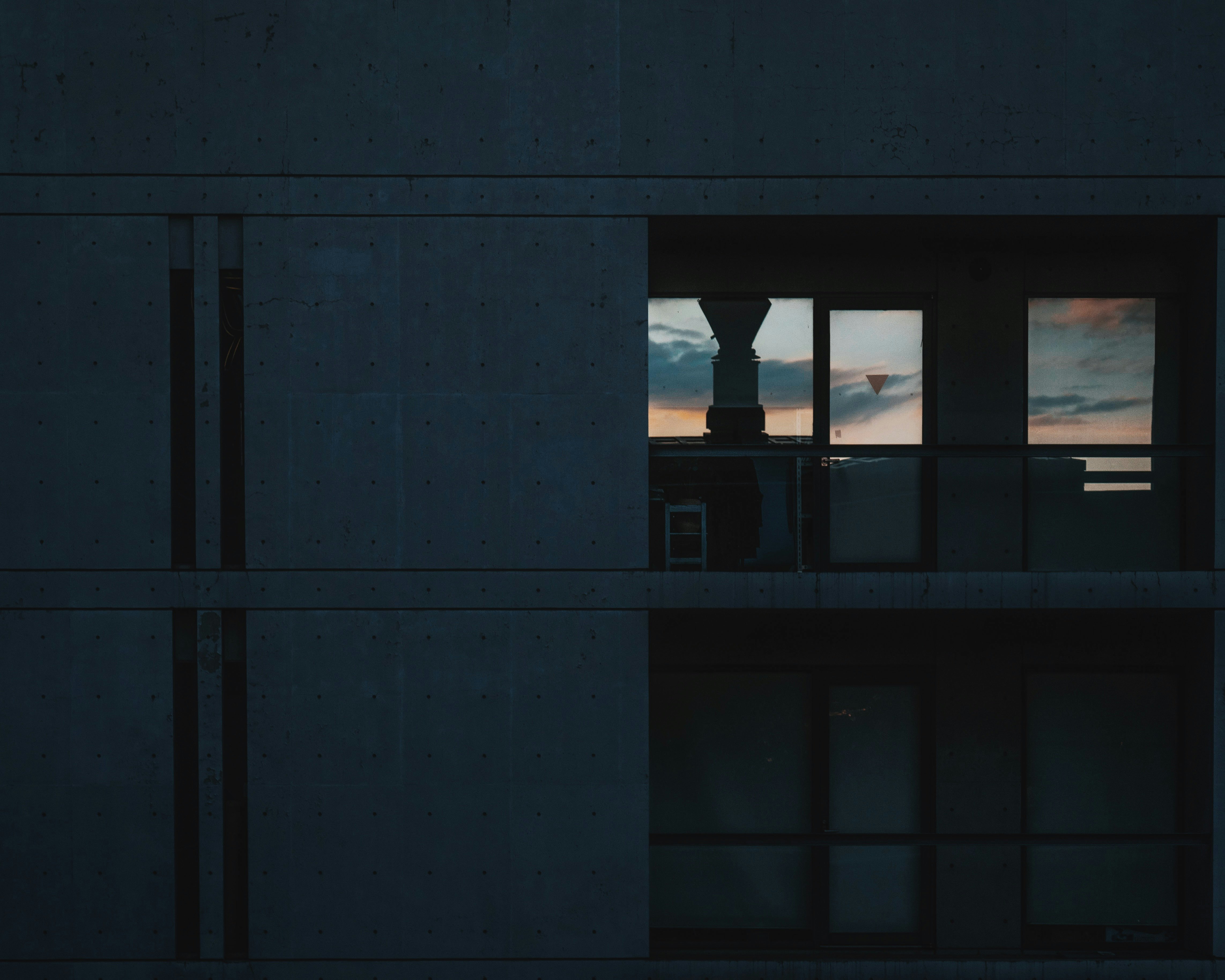 窓のある建物の外壁と夕暮れの空が見える室内の切り取り