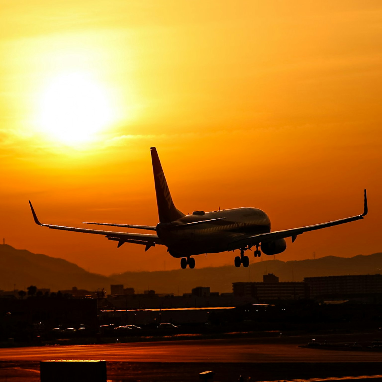 Avión aterrizando contra un fondo de atardecer