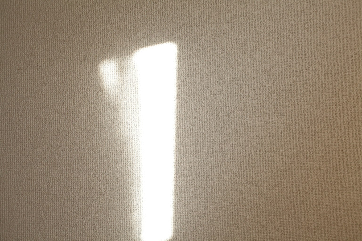 Une ombre simple de lumière blanche se reflétant sur un mur