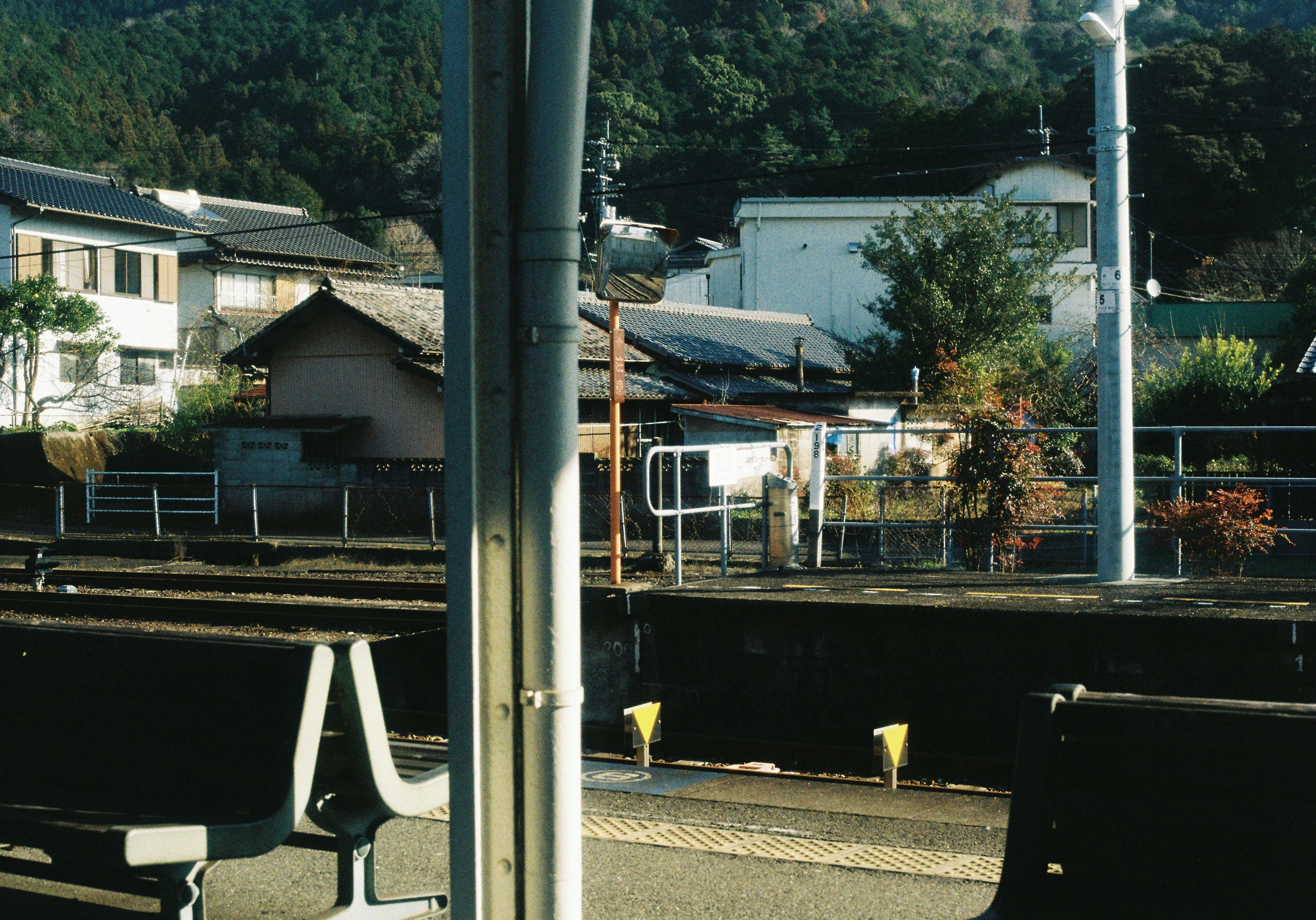 田舎の駅前で線路とホームが見える風景