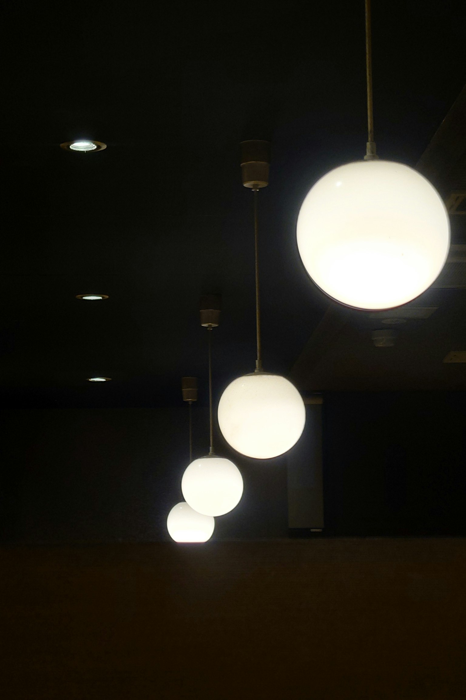 Lampu gantung bulat putih tergantung di latar belakang gelap