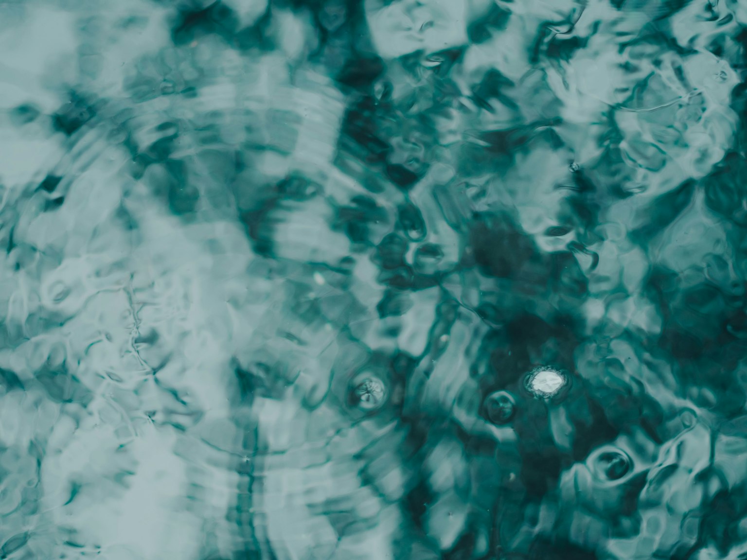 Gros plan sur de l'eau turquoise ondulante avec des reflets