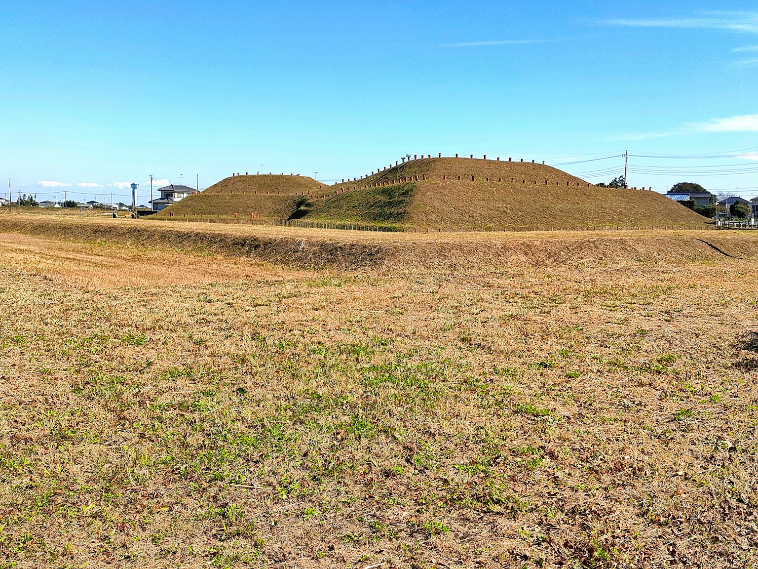 Paisaje con túmulos antiguos contra un cielo amplio y pradera