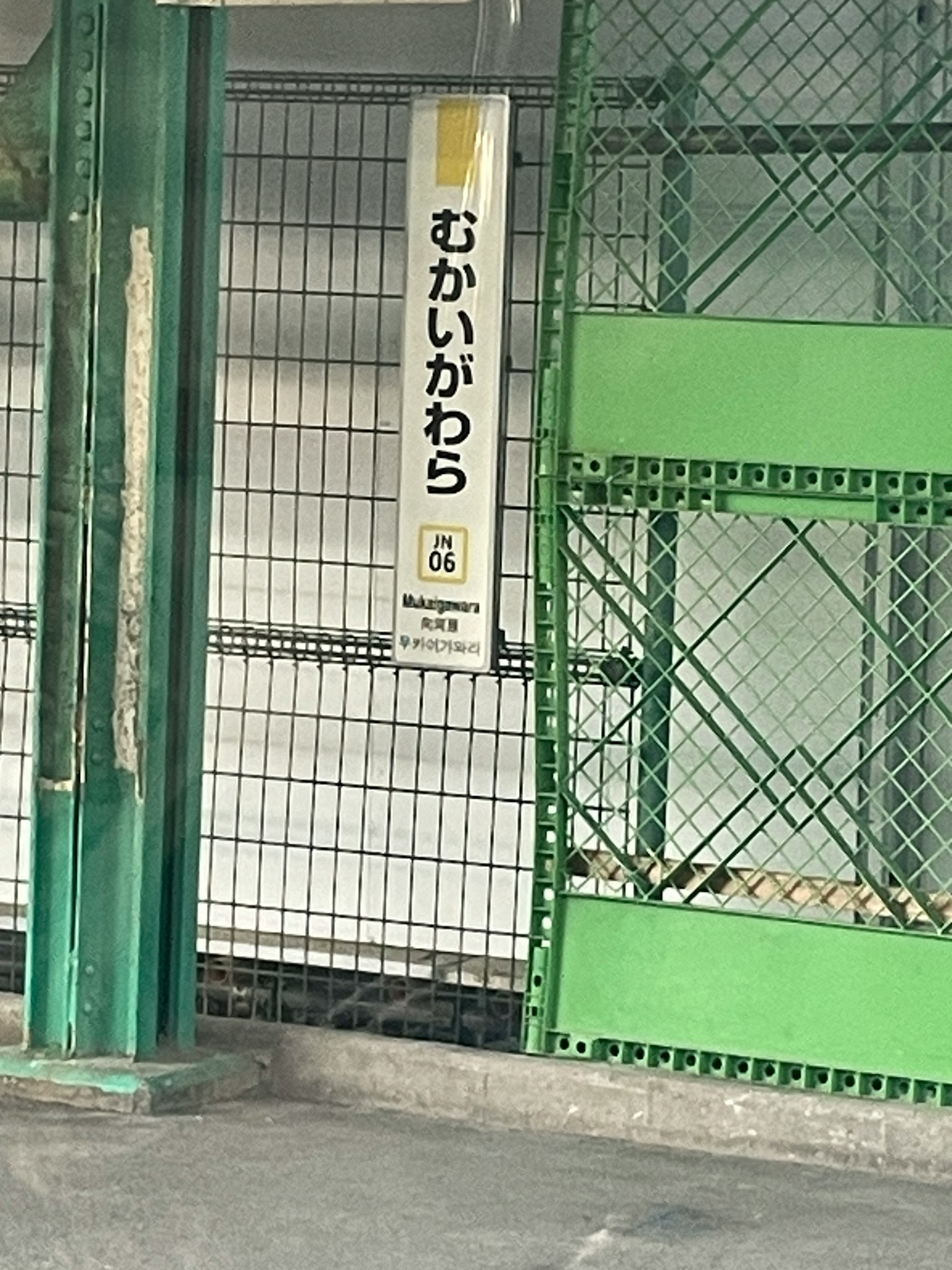 Sezione di un'area di parcheggio con una recinzione verde e un segnale