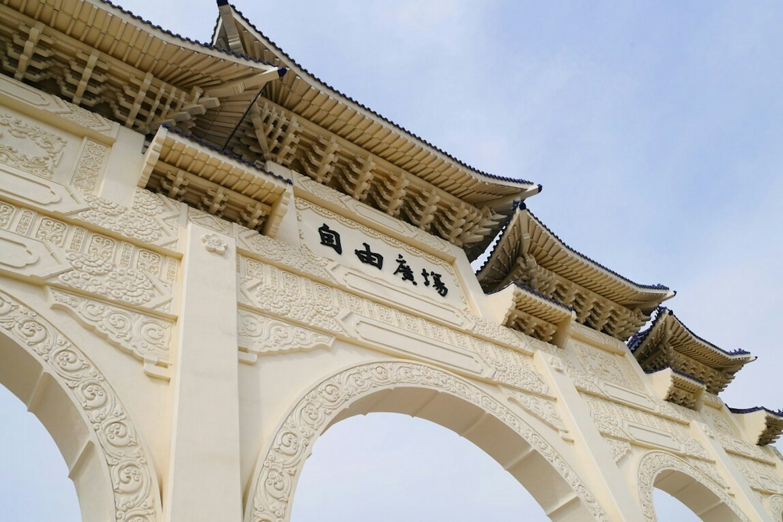 Cổng hình vòm màu trắng với thiết kế mái truyền thống