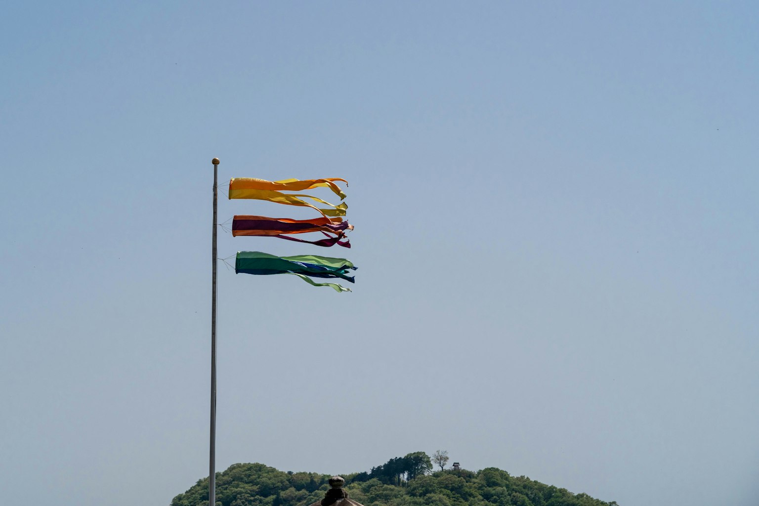 Colorful flags waving in the wind against a clear blue sky