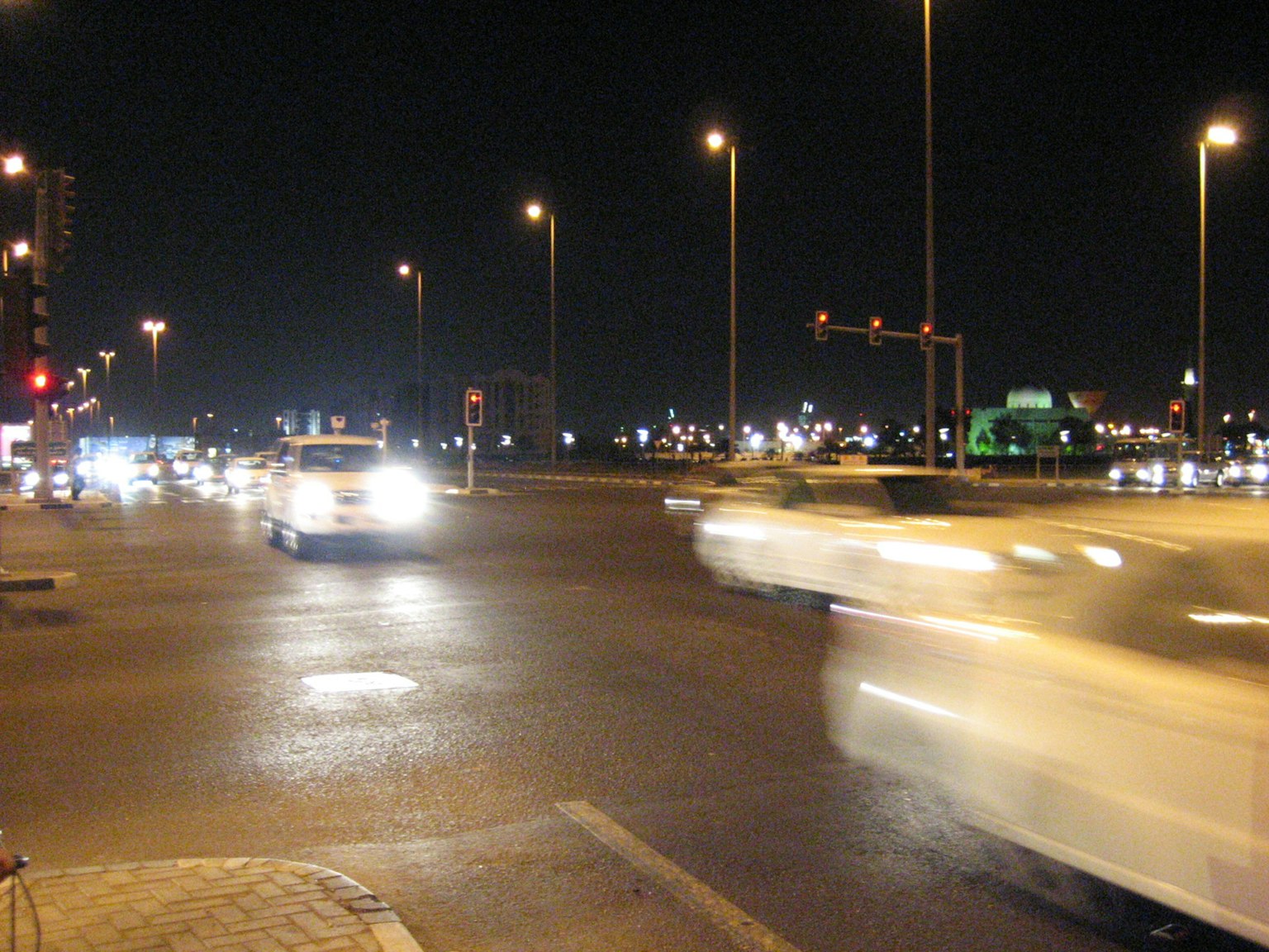 Circulation à un carrefour animé la nuit avec des lampadaires