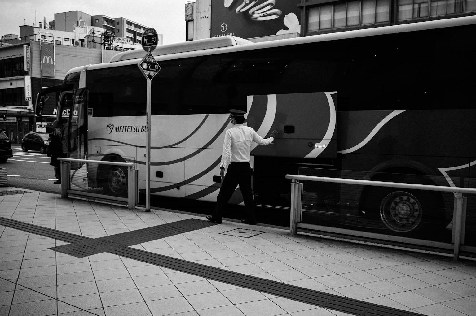 Foto en blanco y negro de una persona subiendo a un autobús en una parada