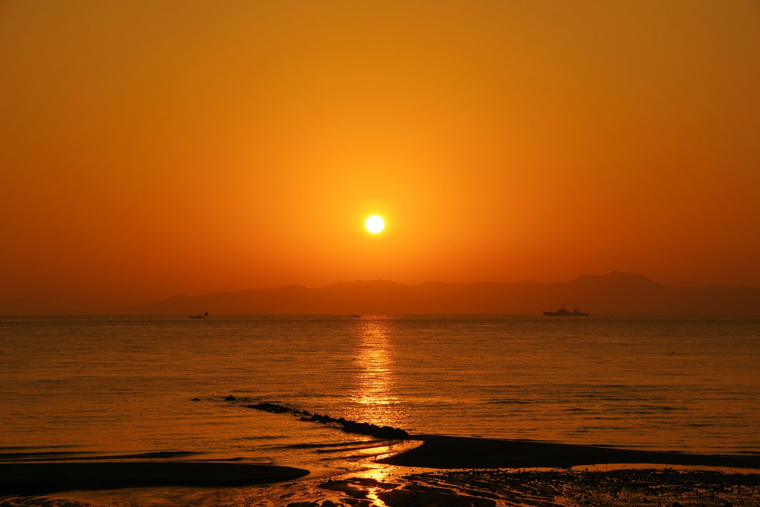 Beautiful sunset over the ocean with orange sky and calm water