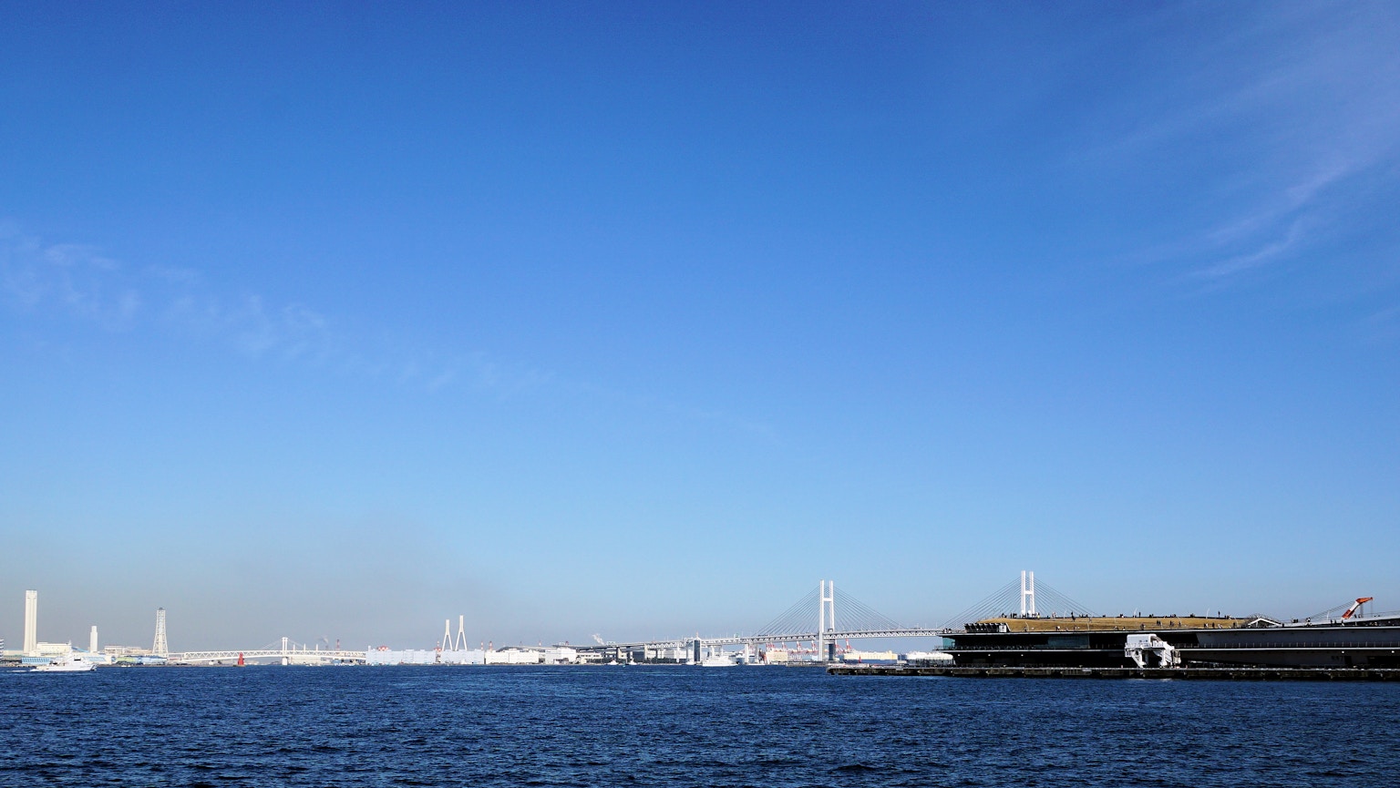 ทิวทัศน์ที่สวยงามของท้องฟ้าสีฟ้าและทะเลพร้อมอาคารท่าเรือมองเห็นได้