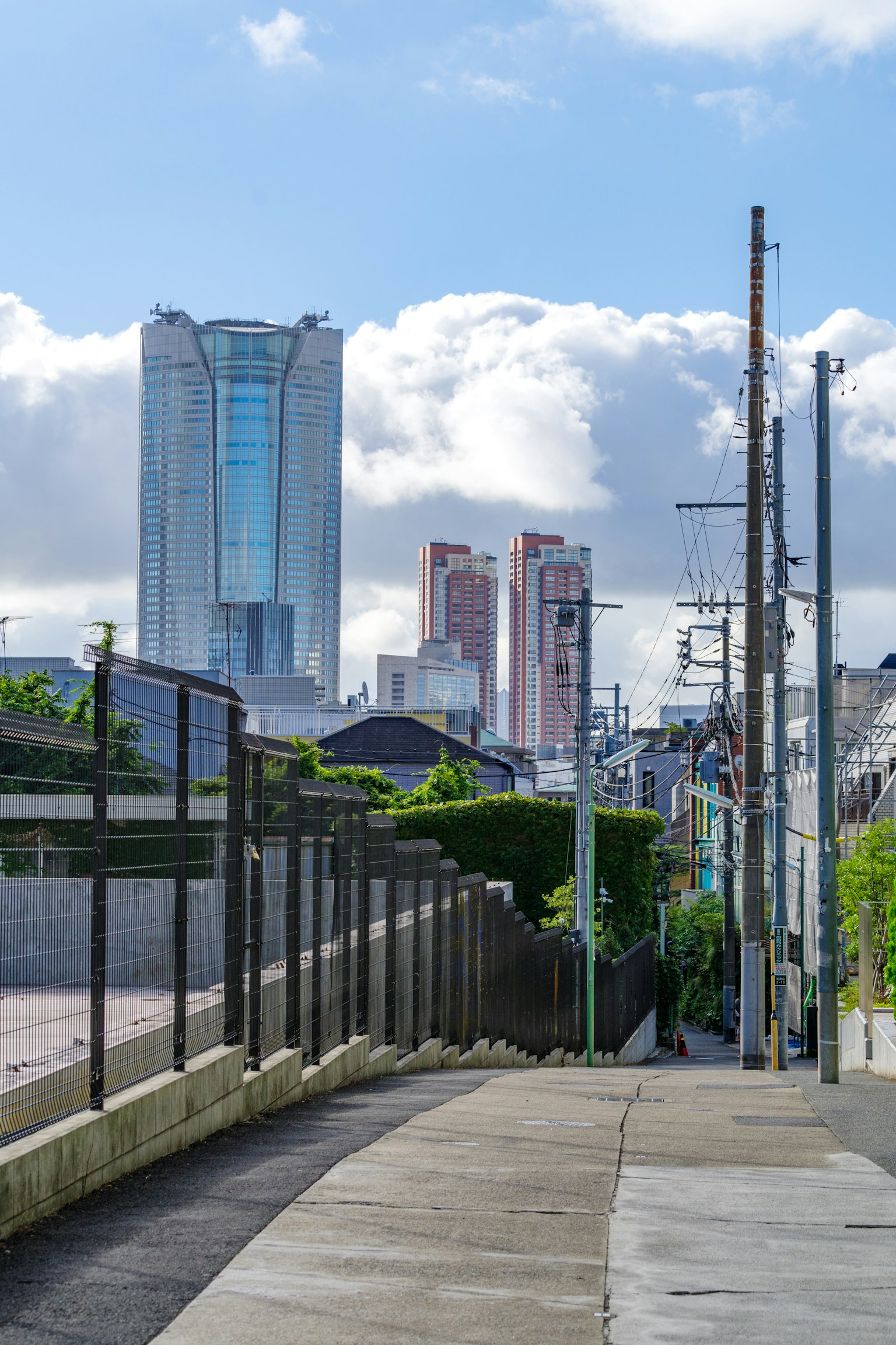 Paesaggio urbano in una giornata serena con grattacieli e cielo azzurro vegetazione lungo il sentiero pavimentato