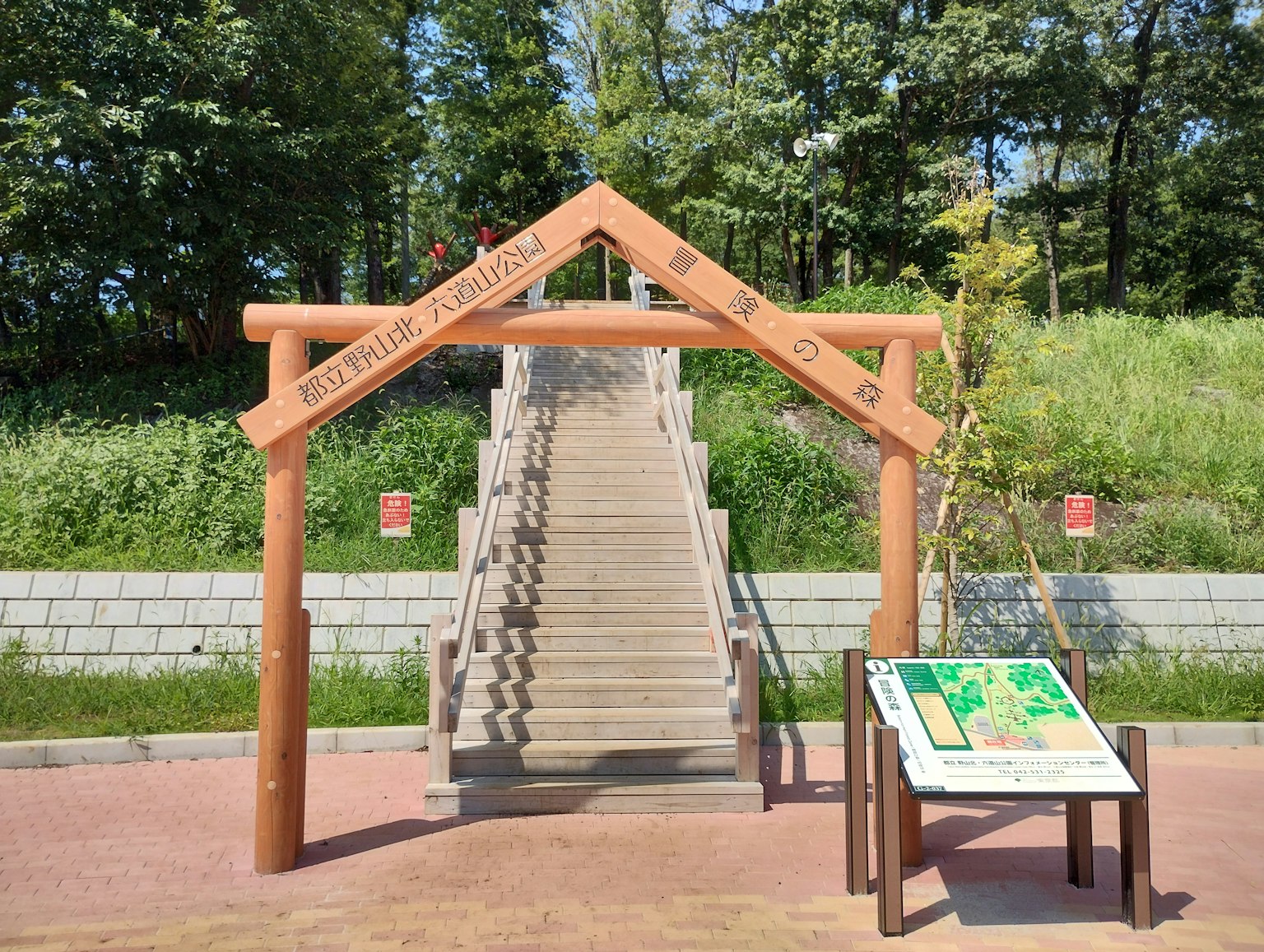 Entrada de un parque con un arco de madera y escaleras