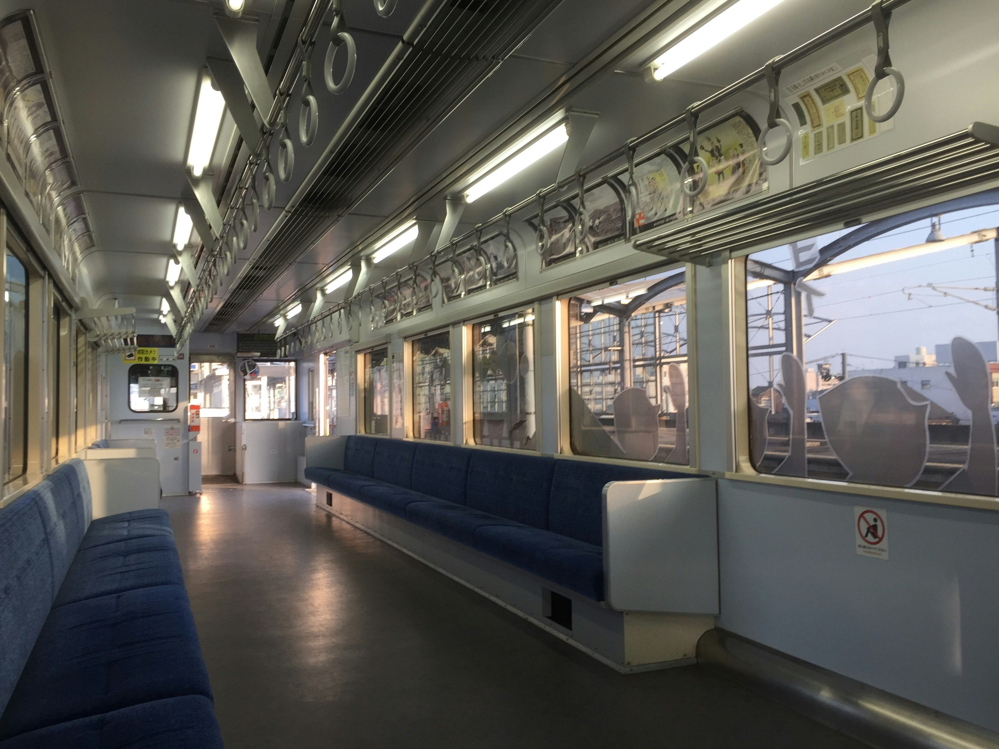 車内のベンチシートが並ぶ鉄道の通路