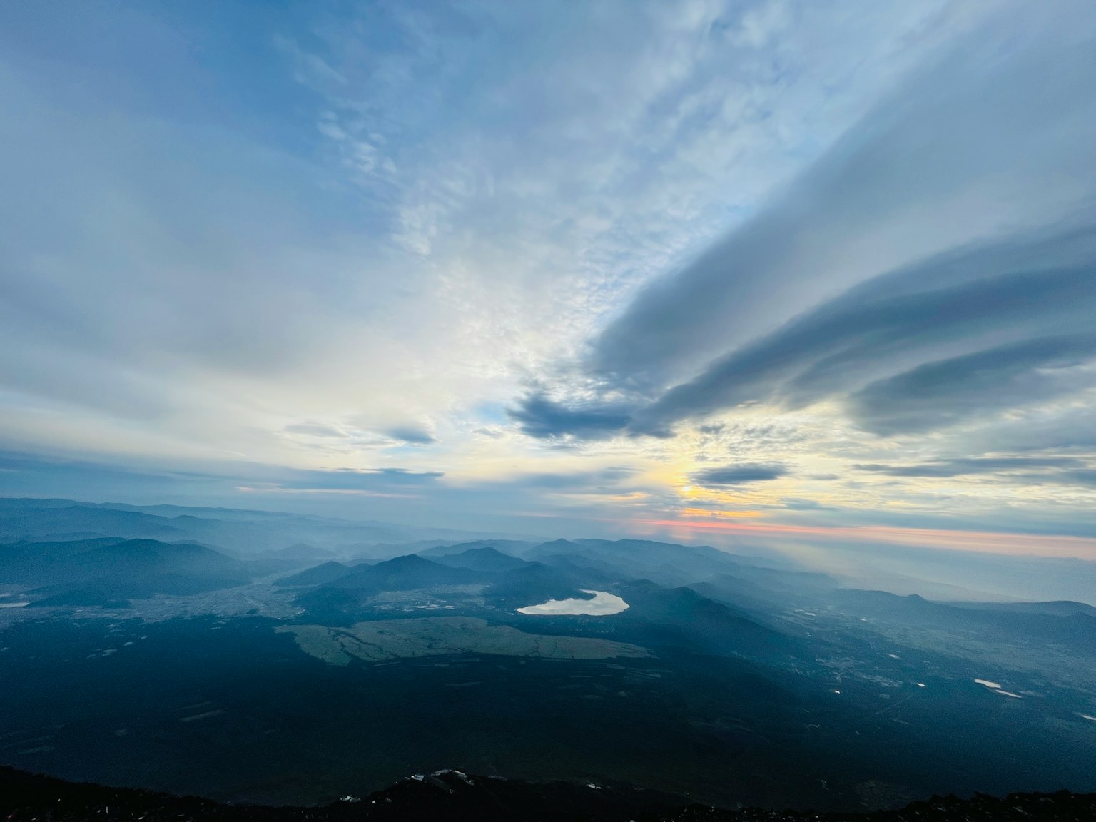 푸른 하늘과 부드러운 구름 아래의 산의 파노라마 전망과 일출의 힌트
