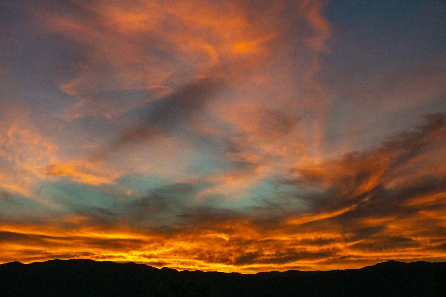 ท้องฟ้าสีส้มและสีน้ำเงินสดใสพร้อมเมฆในขณะพระอาทิตย์ตก