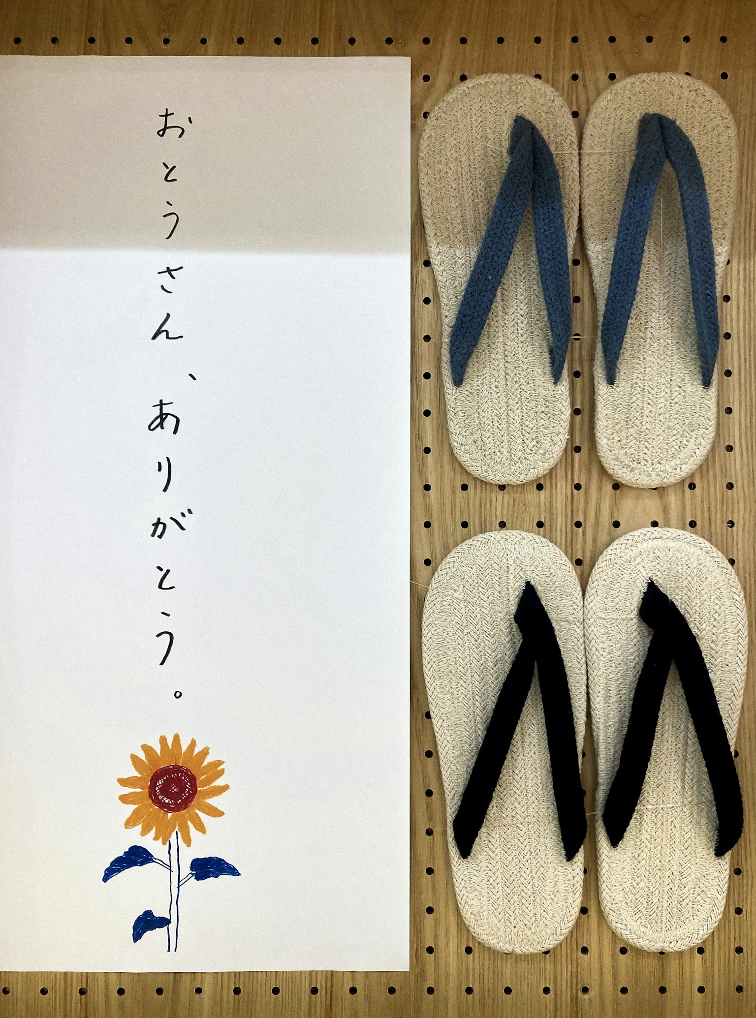 木製のスリッパと感謝のメッセージが描かれたカードが並んでいる