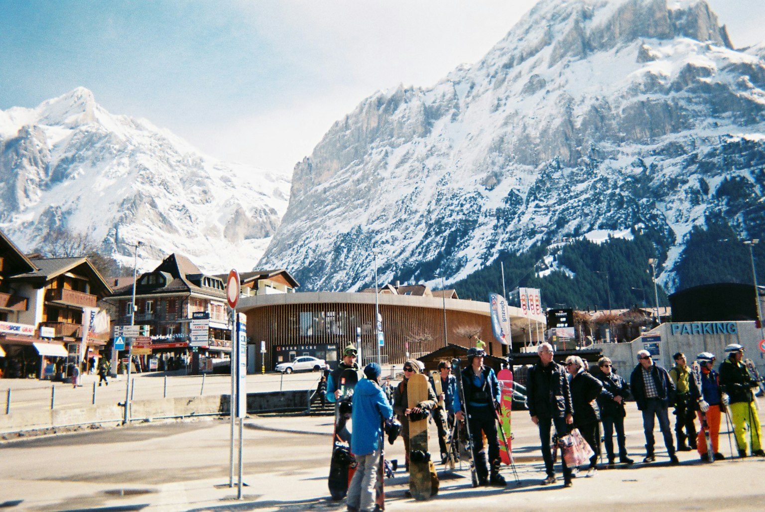 Des personnes faisant la queue dans une station de ski avec des montagnes enneigées en arrière-plan