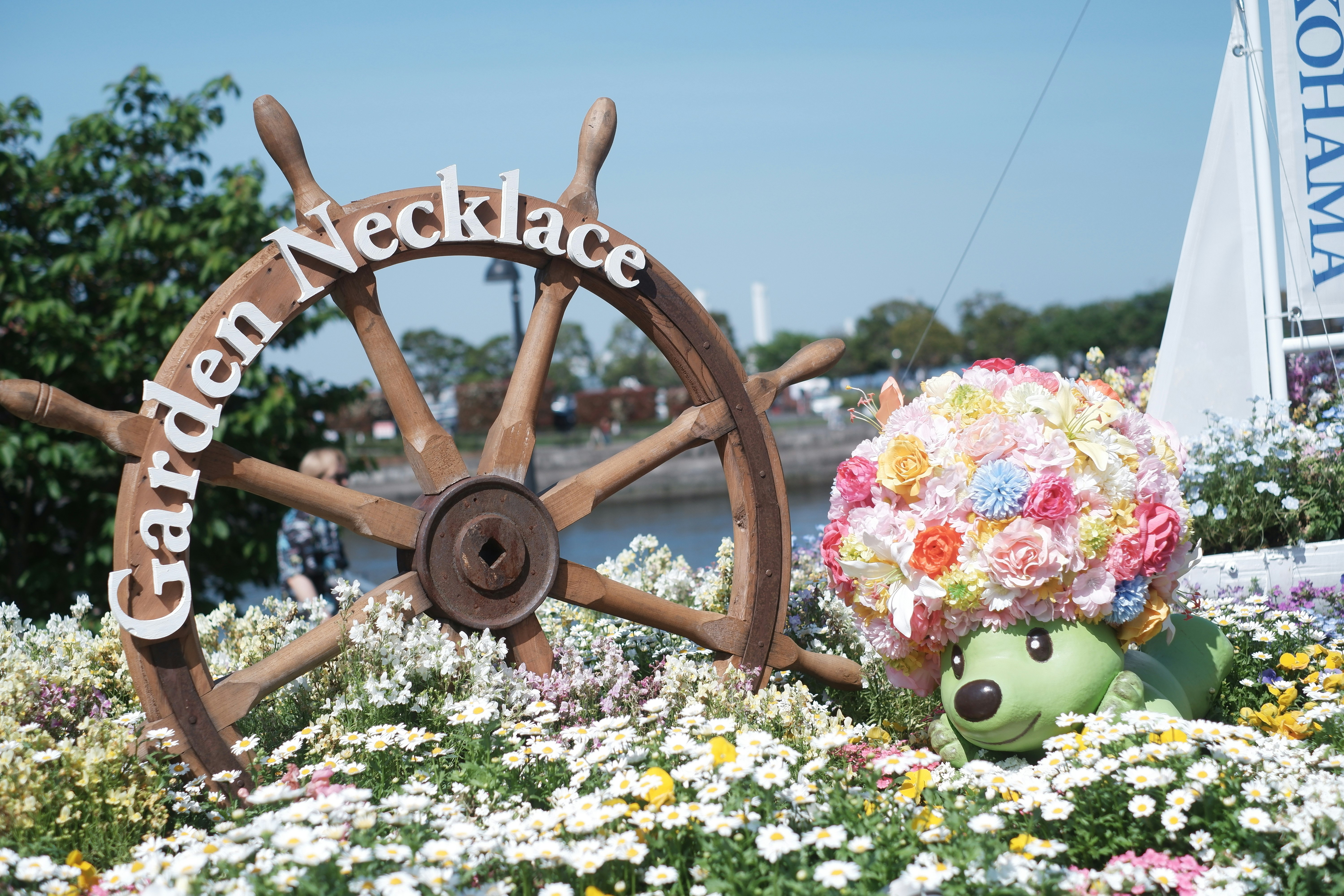 花壇の「Green Necklace」装飾とぬいぐるみのキャラクター