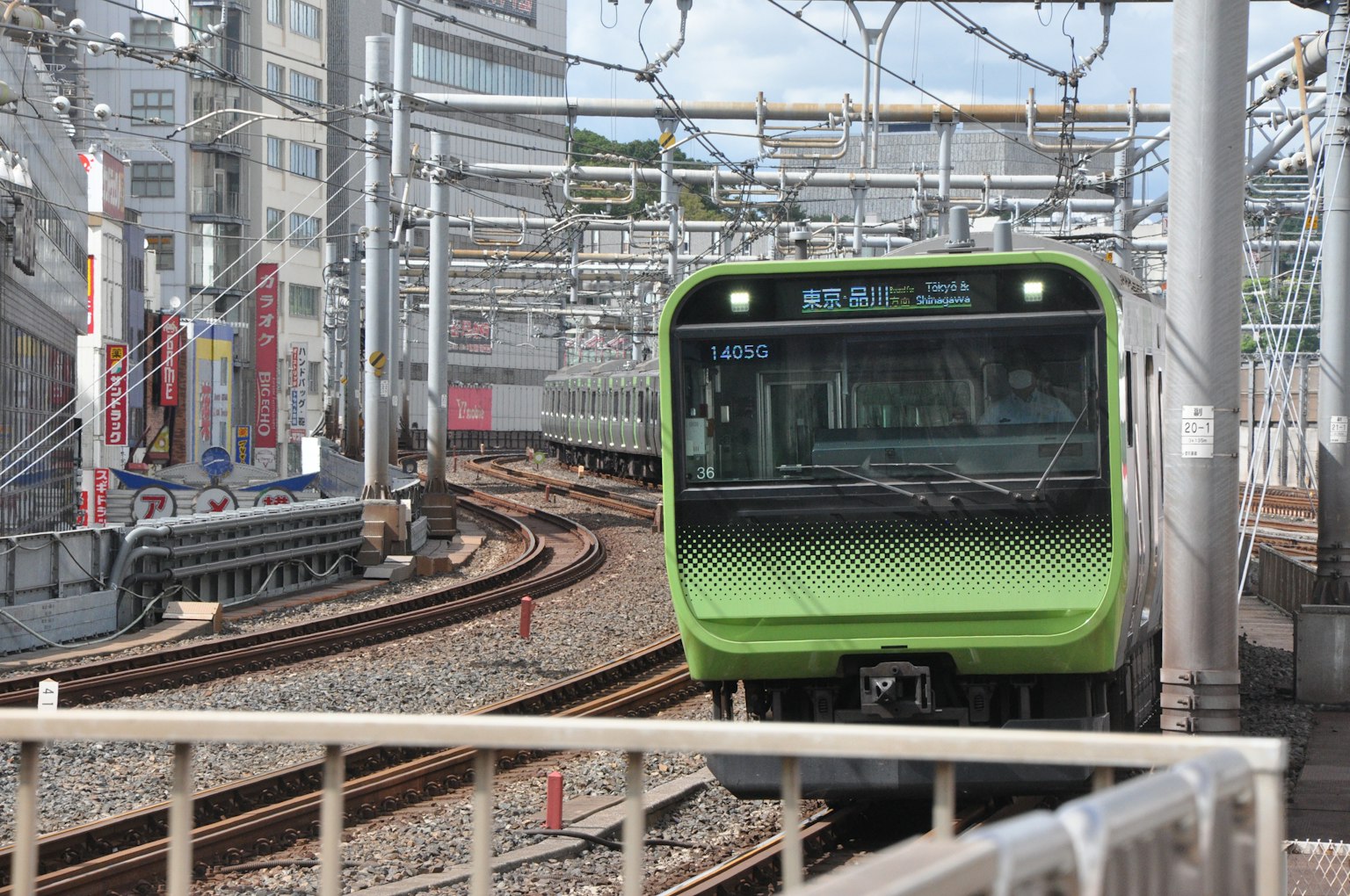 Green train approaching on railway tracks