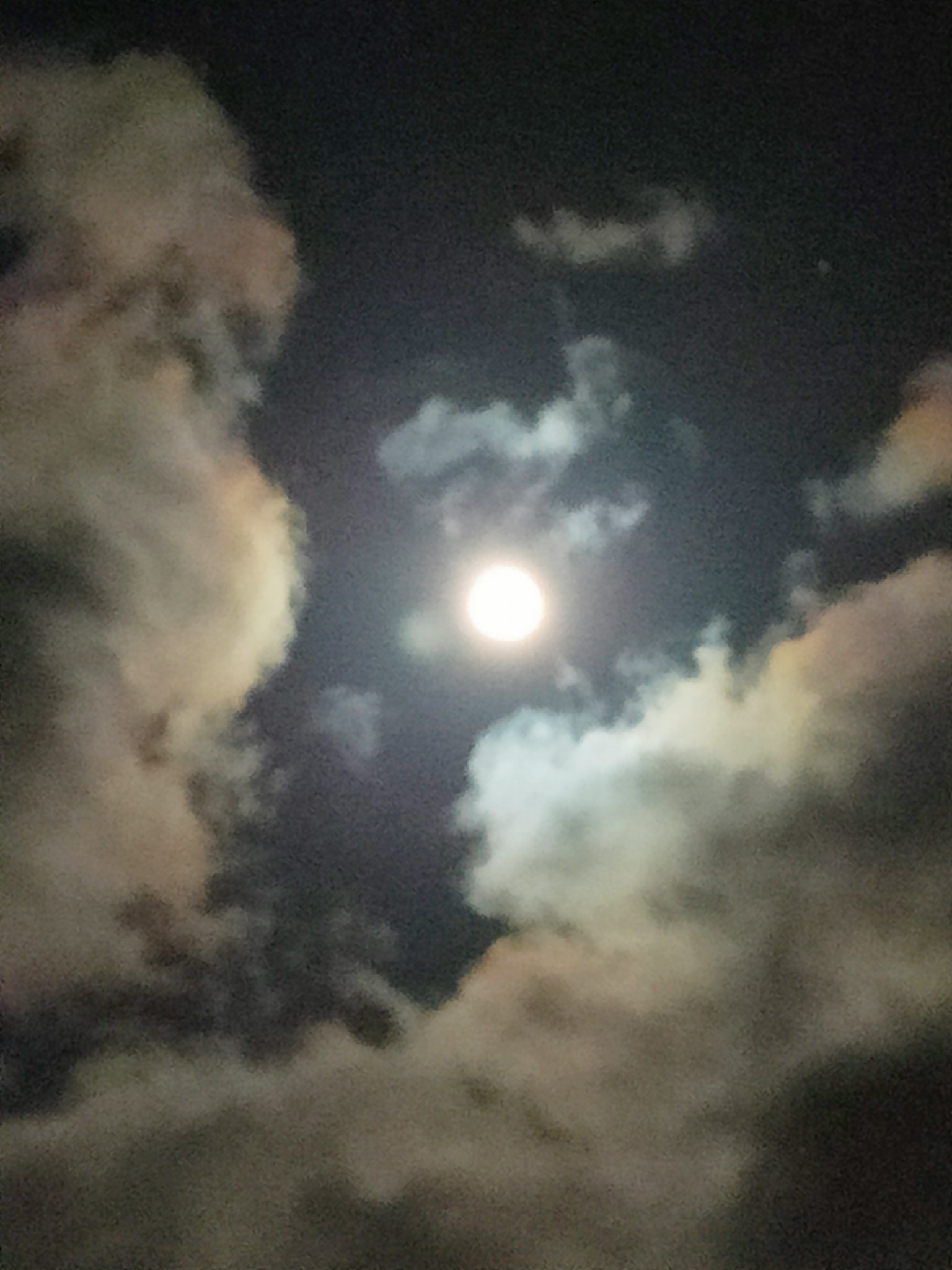 Luna brillante circondata da nuvole nel cielo notturno