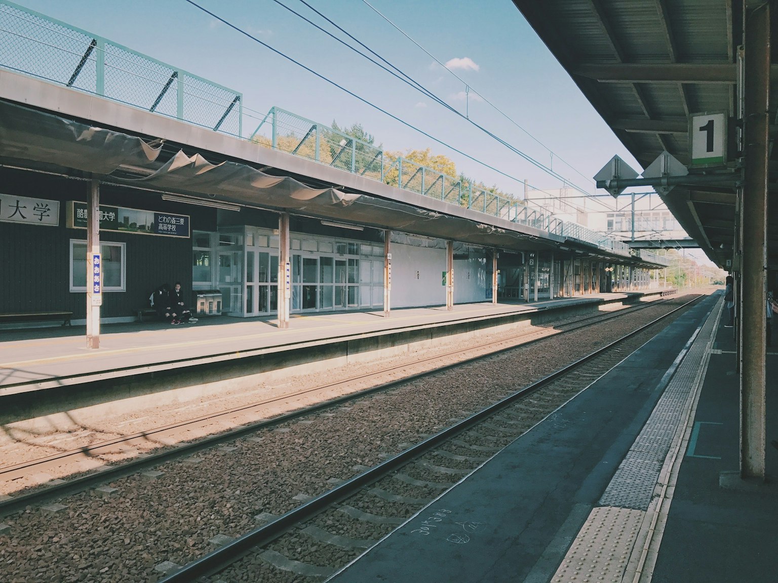 Plateforme de gare tranquille avec des voies ferrées
