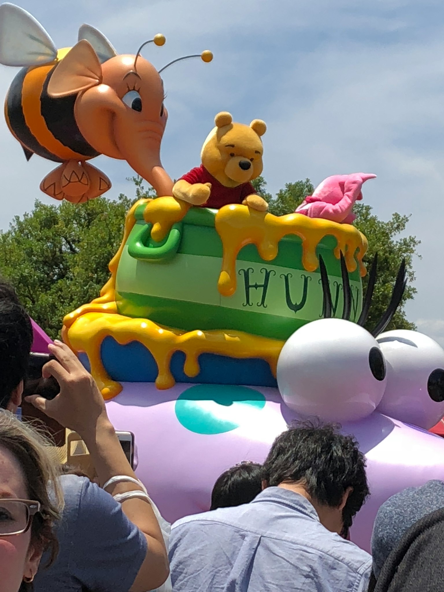 色彩繽紛的遊行花車，維尼熊和一隻蜜蜂在蜂蜜蛋糕上
