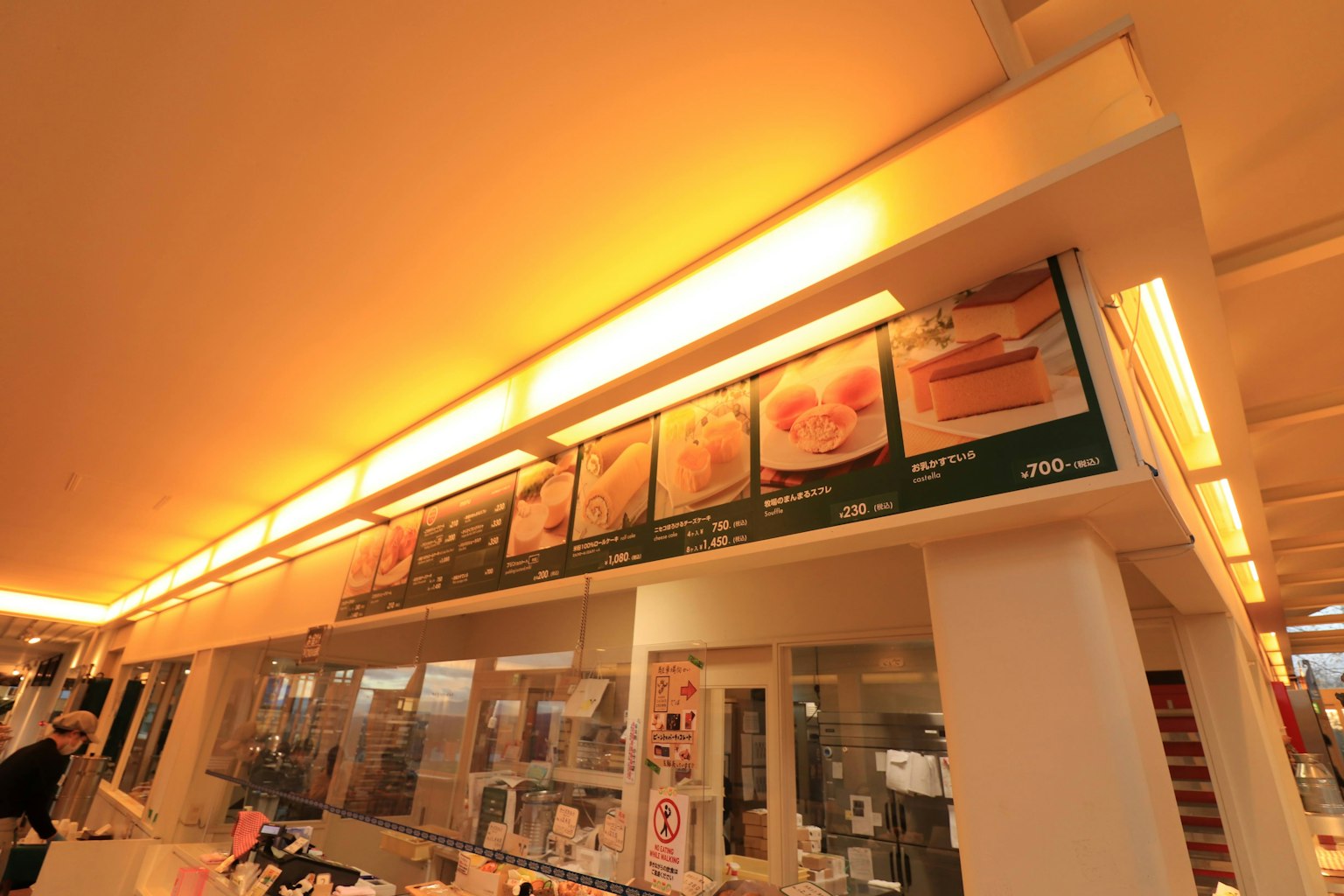 เคาน์เตอร์ร้านกาแฟที่มีเมนูสว่างและแสงอุ่น
