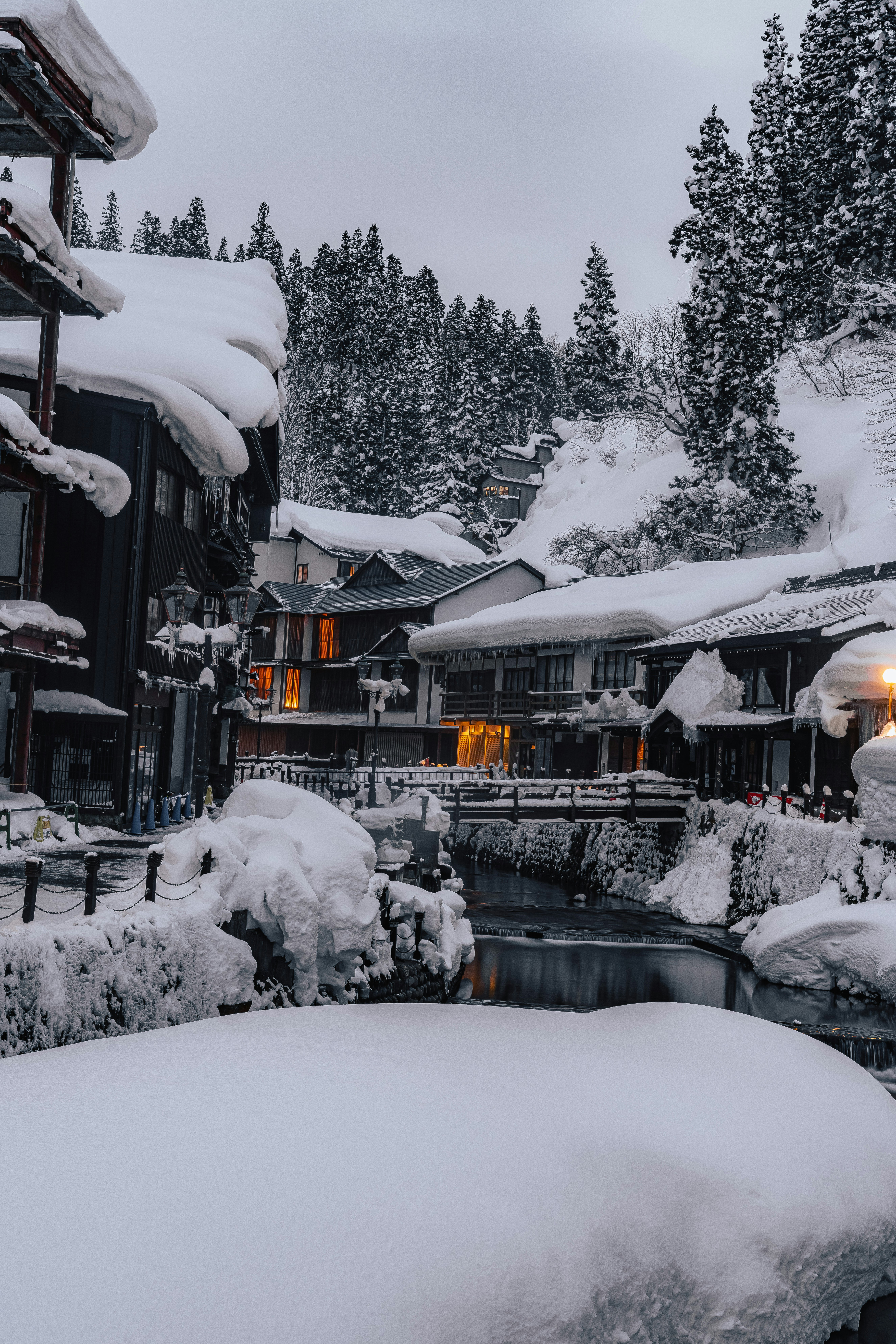 雪に覆われた温泉街の中庭と露天風呂のある景色
