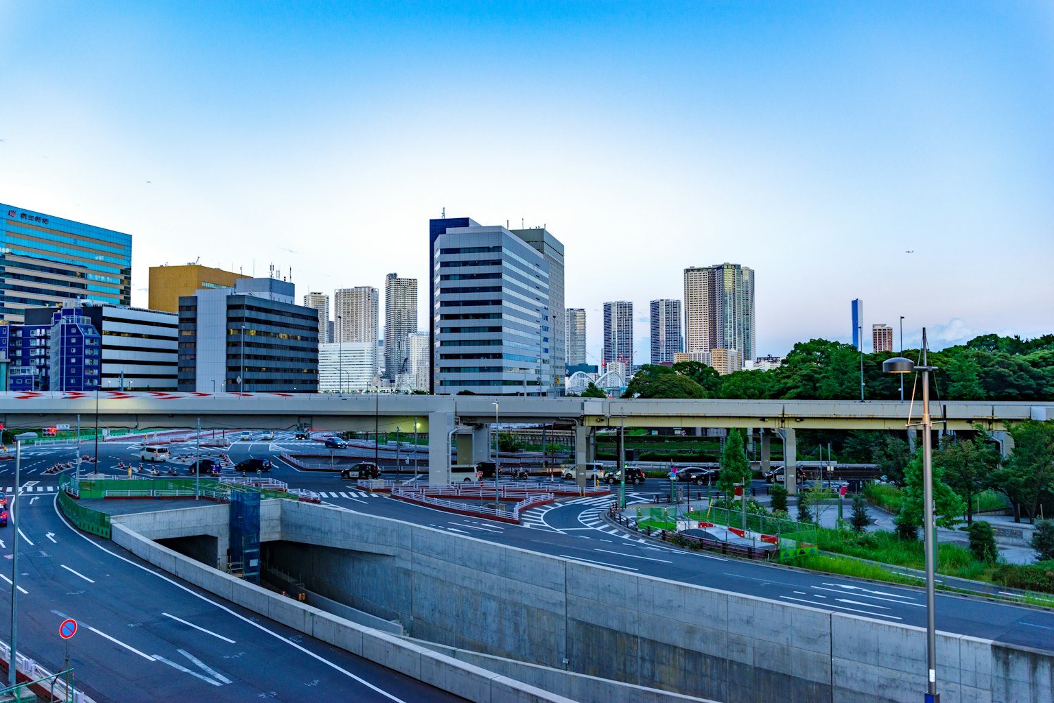 ทิวทัศน์เมืองโตเกียวที่มีตึกสูงและถนนสายหลักใต้ท้องฟ้าสีฟ้า