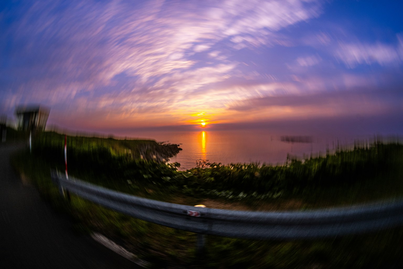 海辺の夕日が映る美しい風景　色とりどりの雲が広がる空