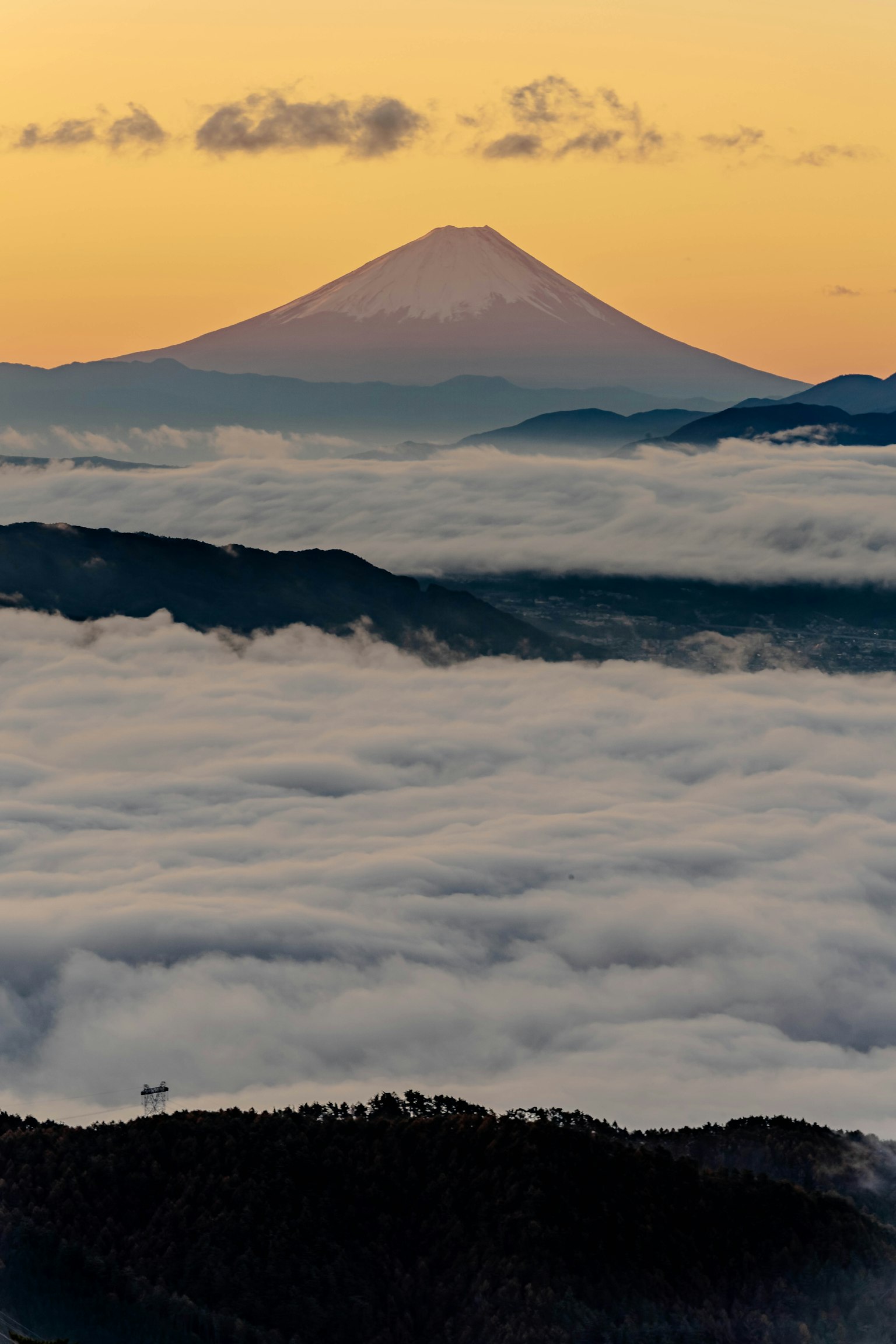 富士山在日落时分高耸于云海之上
