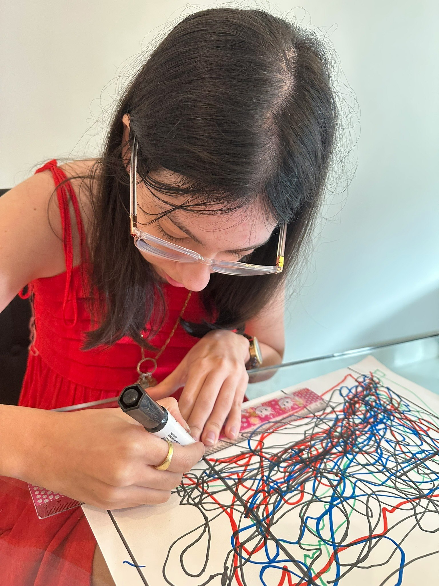 マスク姿の女性が机上で配線図を描いている