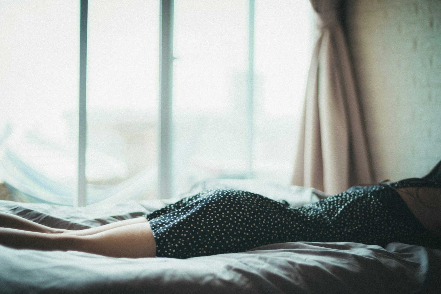 Una scena che mostra le gambe di una donna sdraiata vicino a una finestra
