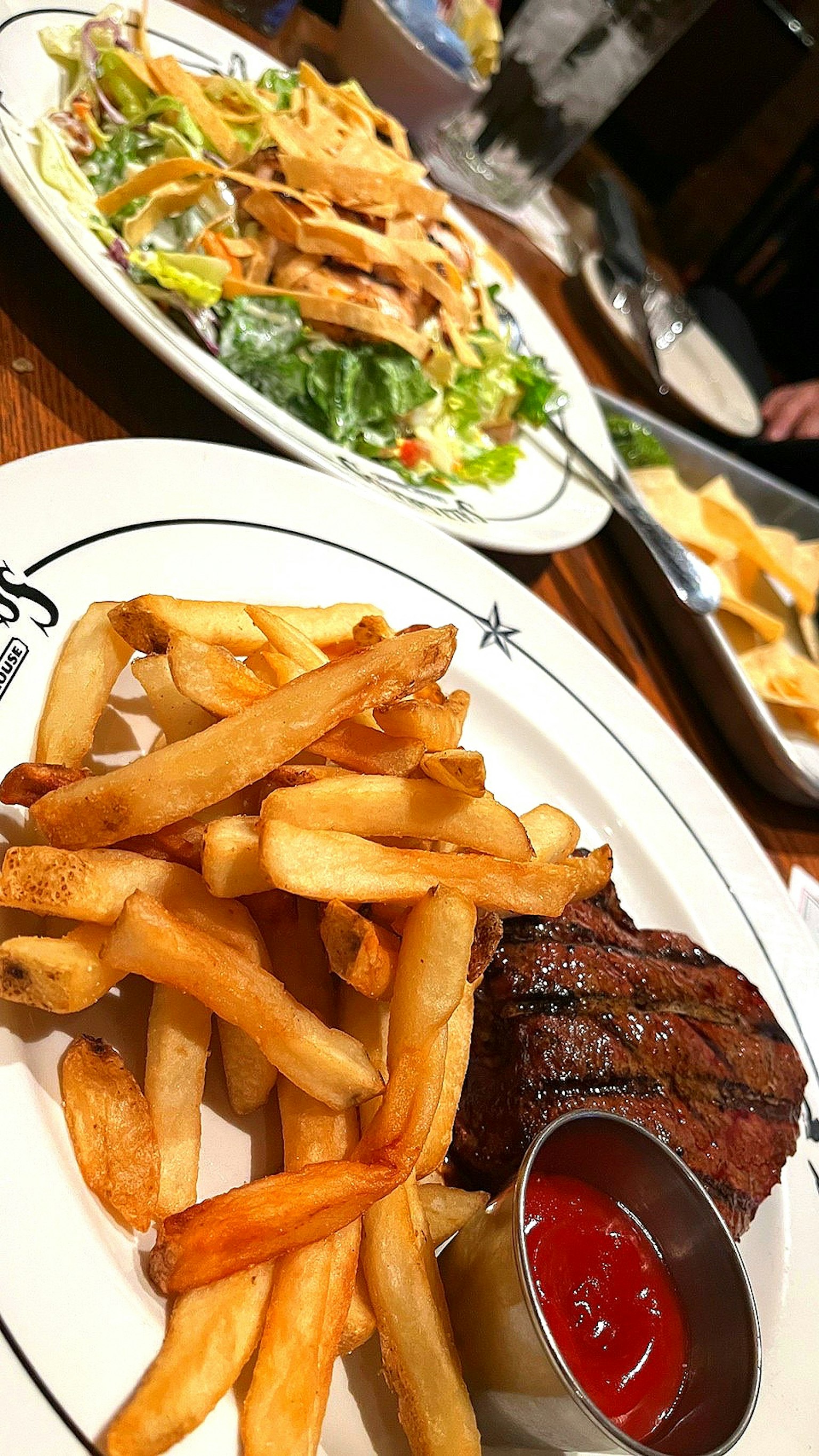 Gros plan d'une assiette avec des frites et un steak grillé avec un côté de ketchup dans un cadre de restaurant